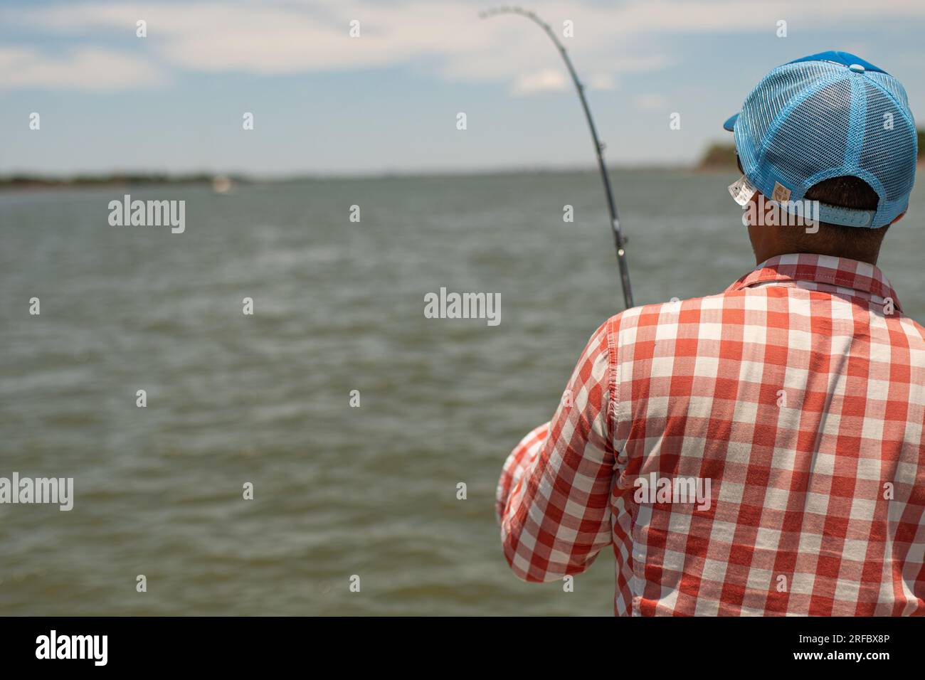 Grown white man holding a fishing rod on a fishing day. Stock Photo