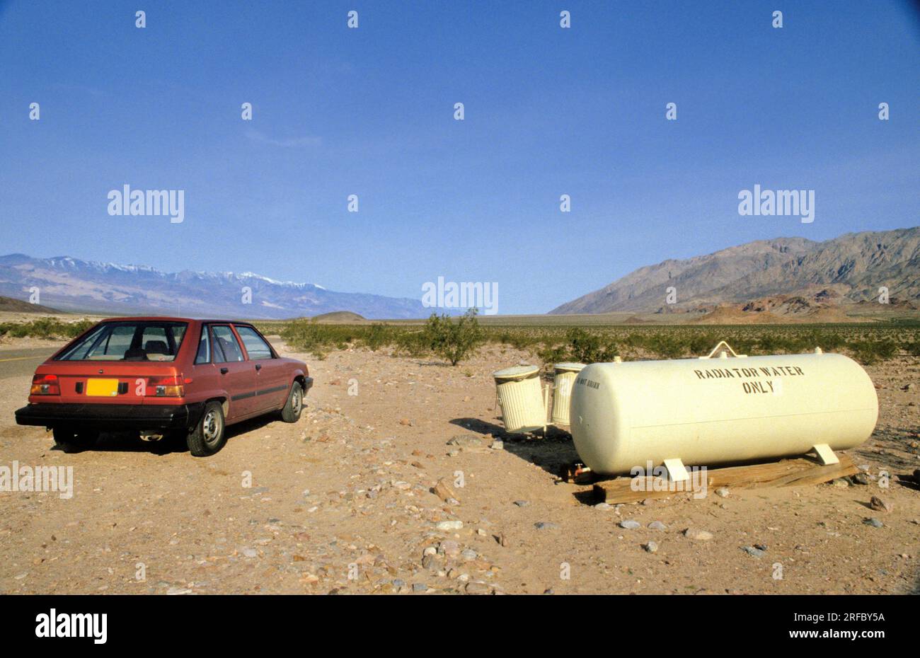 A car stops at tanks with radiator water in the desert of Death Valley, California, USA Stock Photo