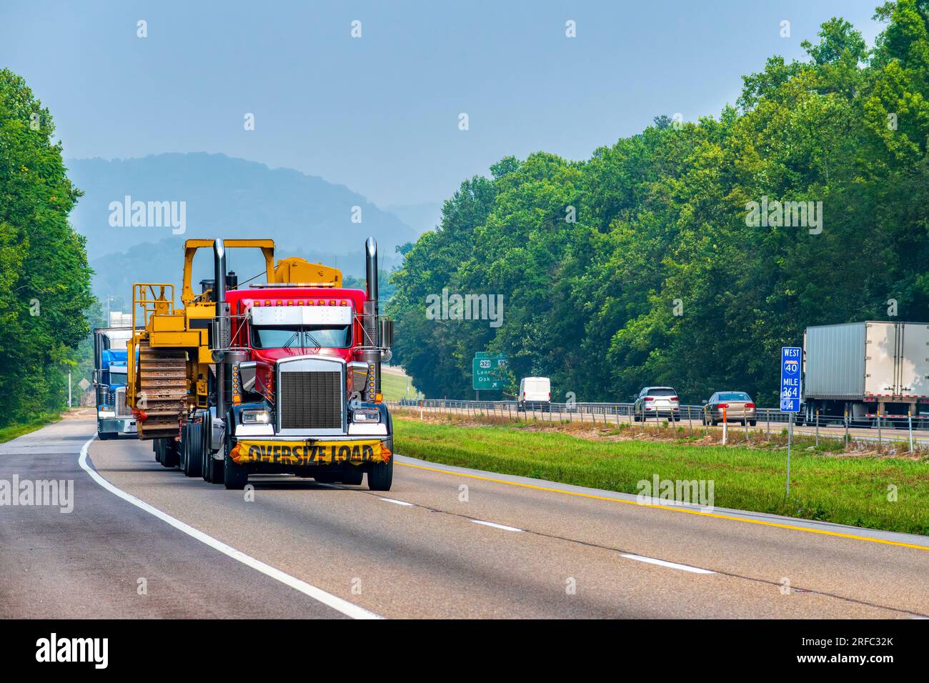 Horizontal shot of heavy machinery being transported on a Tennessee interstate highway. Stock Photo