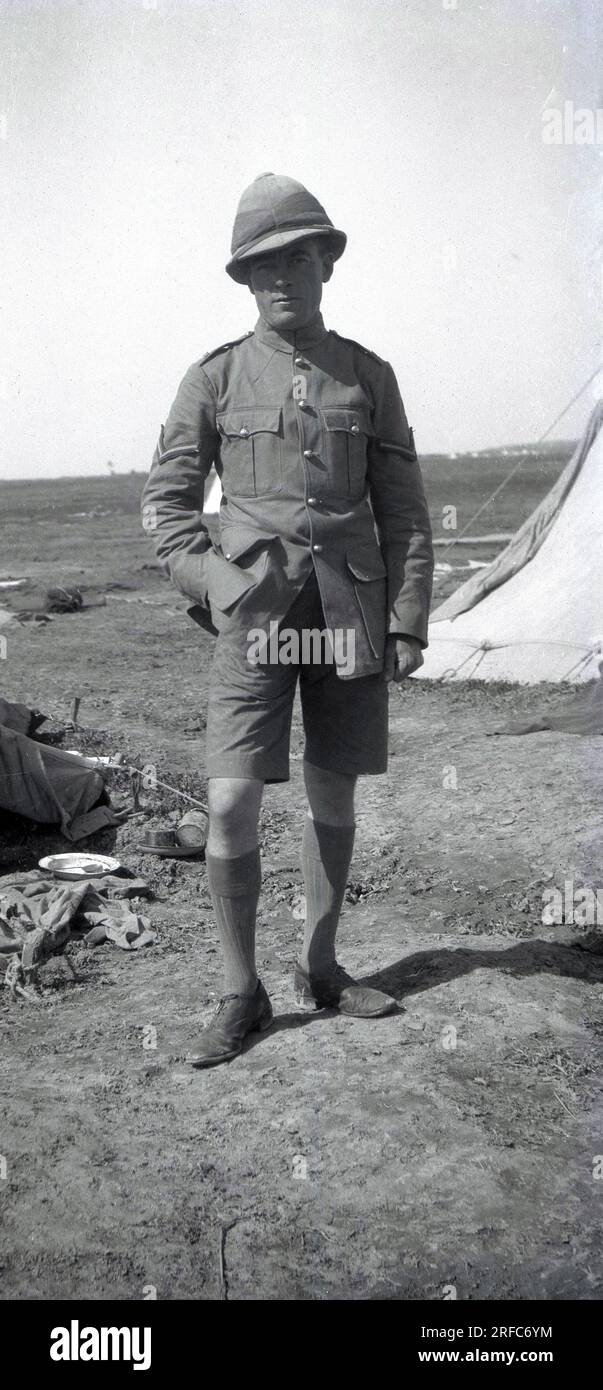 circa 1915, historical, WW1, British soldier in uniform, tunic, shorts and long socks, standing outside a tent at his camp. Stock Photo