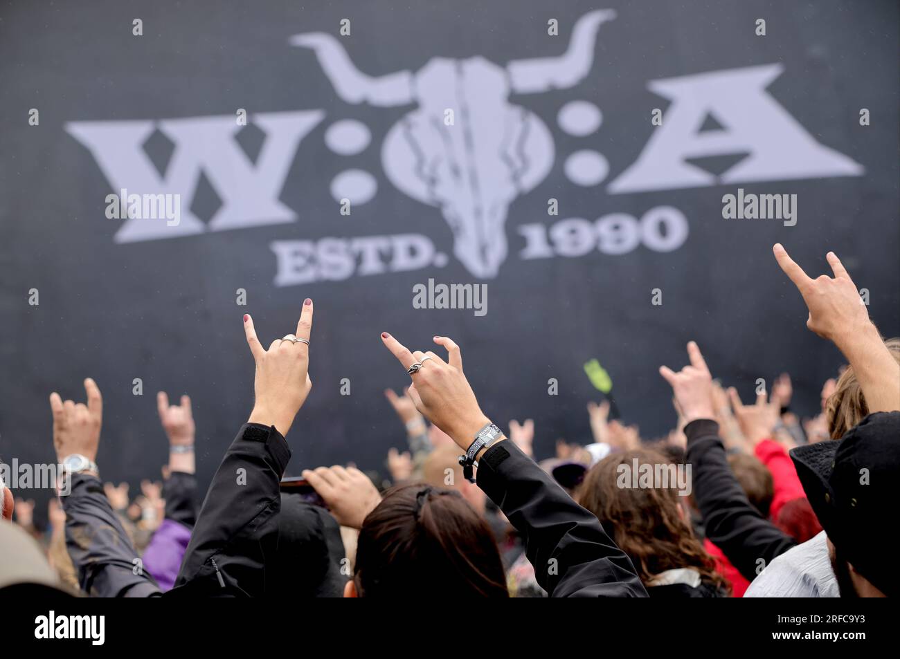 Wacken, Germany. 02nd Aug, 2023. Metal fans celebrate after the opening of the so-called 'infield' in front of the 'Faster Stage', one of the two main stages on the festival grounds. The Wacken Open-Air (WOA) from August 2 to 5 is considered the biggest heavy metal festival in the world. Credit: Christian Charisius/dpa/Alamy Live News Stock Photo