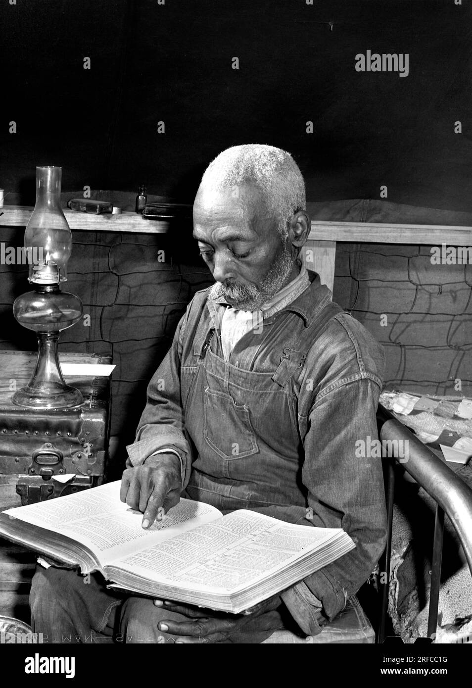 Evicted sharecropper reading bible, Butler County, Missouri, USA, November 1939 Stock Photo