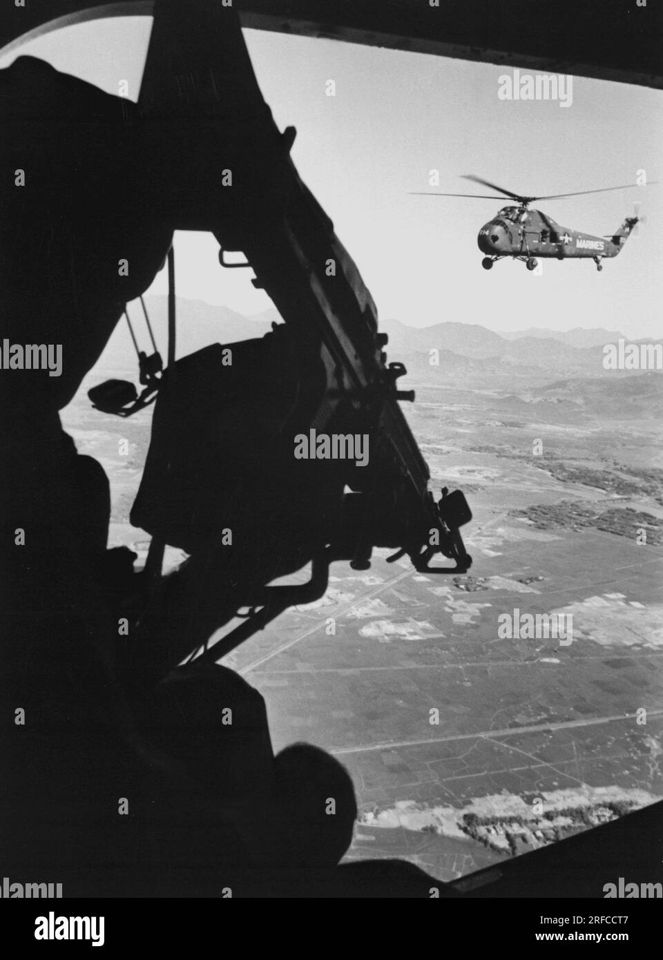 VIETNAM - 1965 - Helicopter gunner during combat in Vietnam against North Vietnamese communist forces in an unidentified area of South Vietnam - Photo Stock Photo