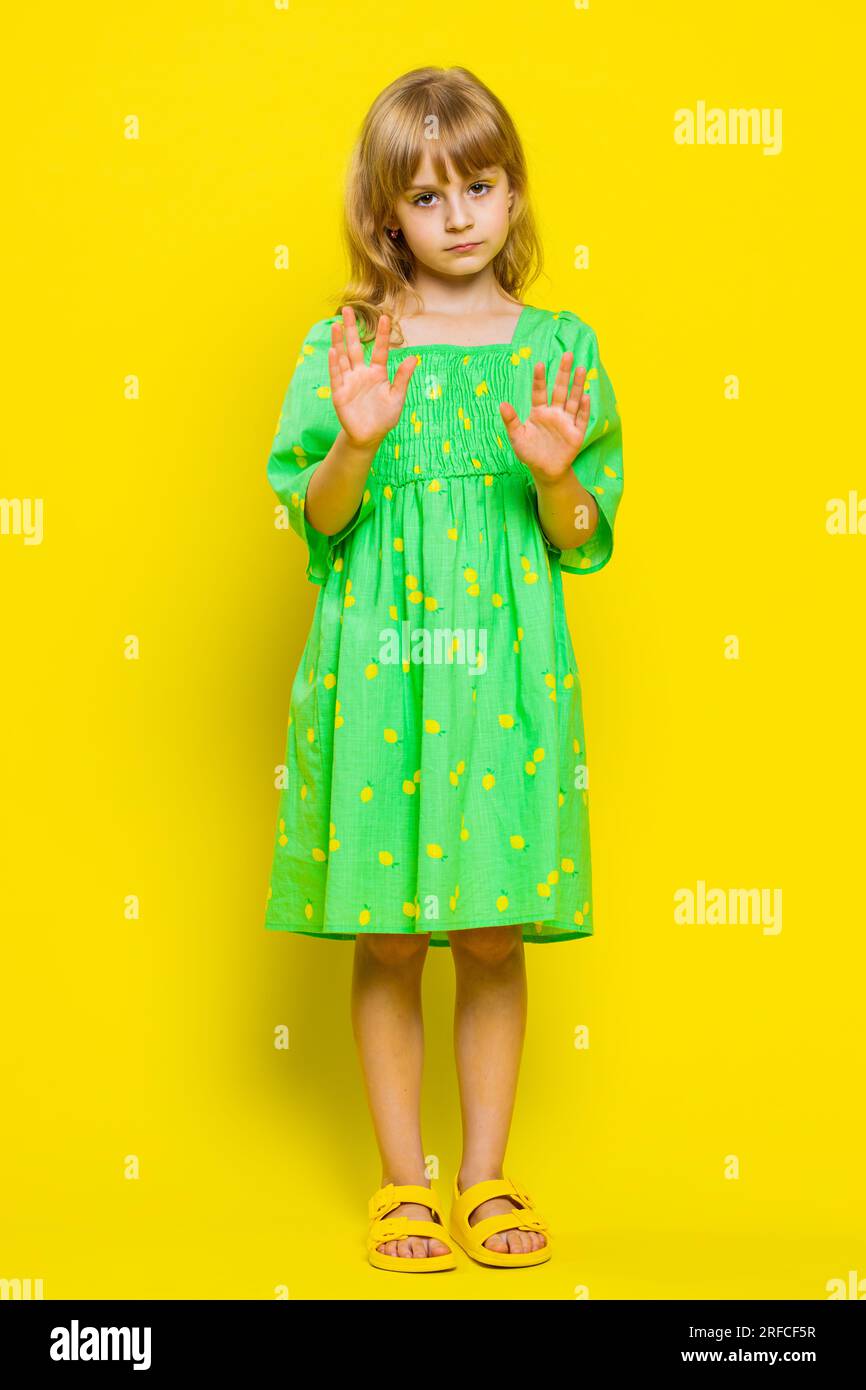 Hey you, be careful. Blonde child girl kid warning with admonishing finger gesture, saying no, be careful, scolding and giving advice to avoid danger, disapproval sign. Preteen children. Vertical Stock Photo