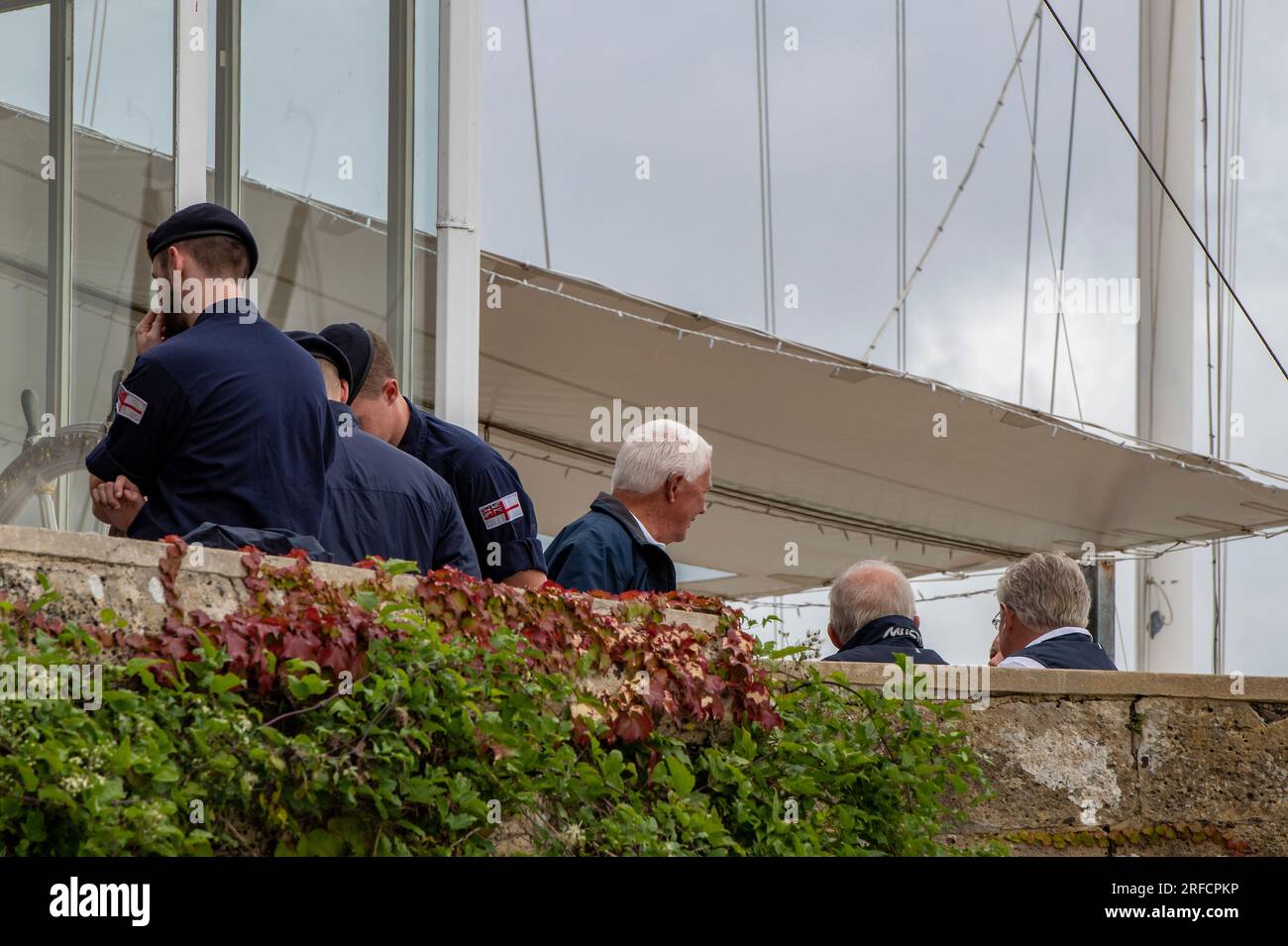 officials at cowes week yachting regatta on the isle of wight gathered on the balcony of the royal yacht squadron in cowes Stock Photo