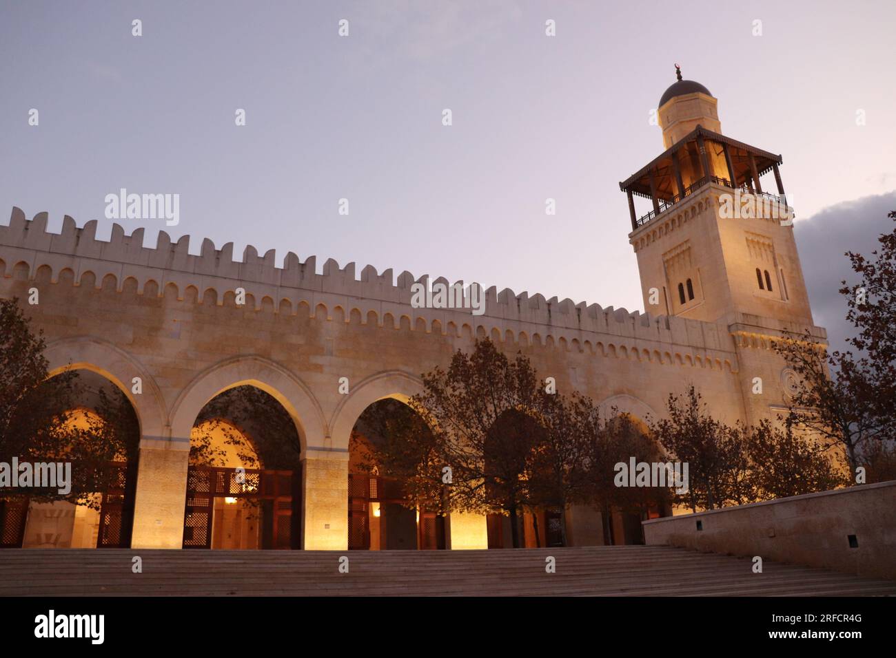 Arab Islamic mosque in Amman, Jordan - minaret, yellow lights, trees in autumn (King Hussein Bin Talal Mosque) Stock Photo