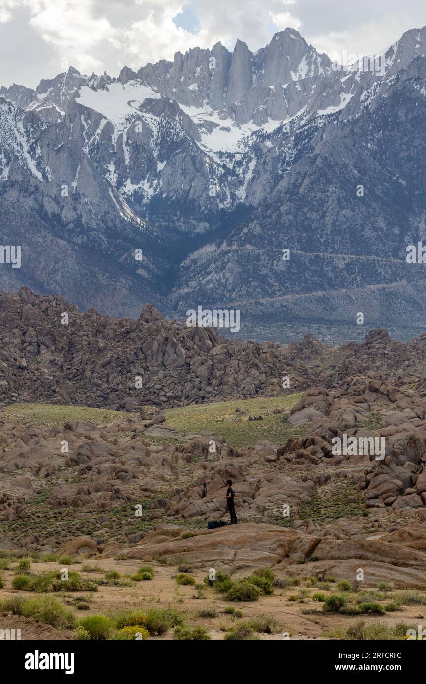 Lone man in Alabama Hills with the snow covered eastern sierras in the