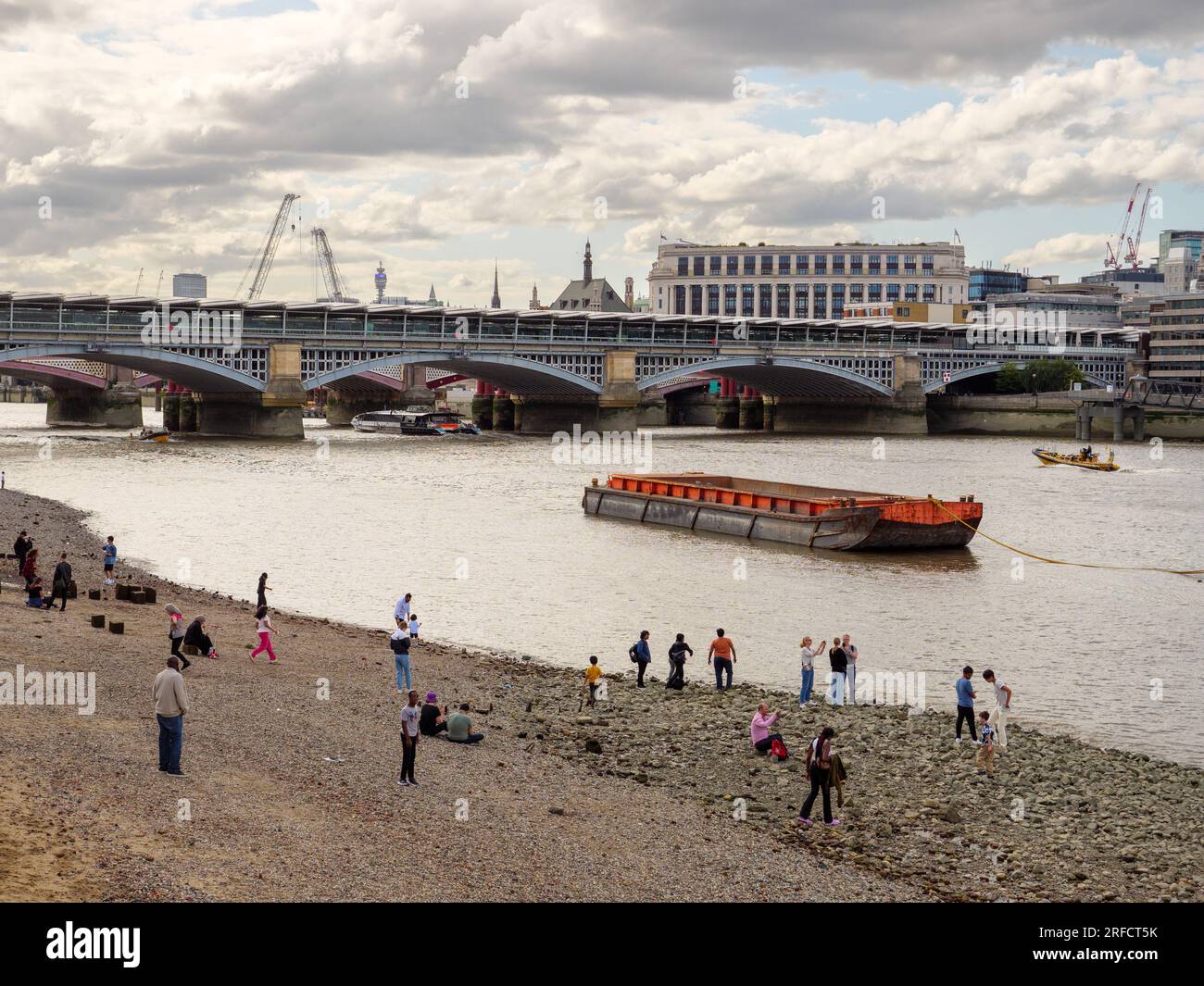 People on the Bankside Beach of the River Thames at low tide, London, UK Stock Photo