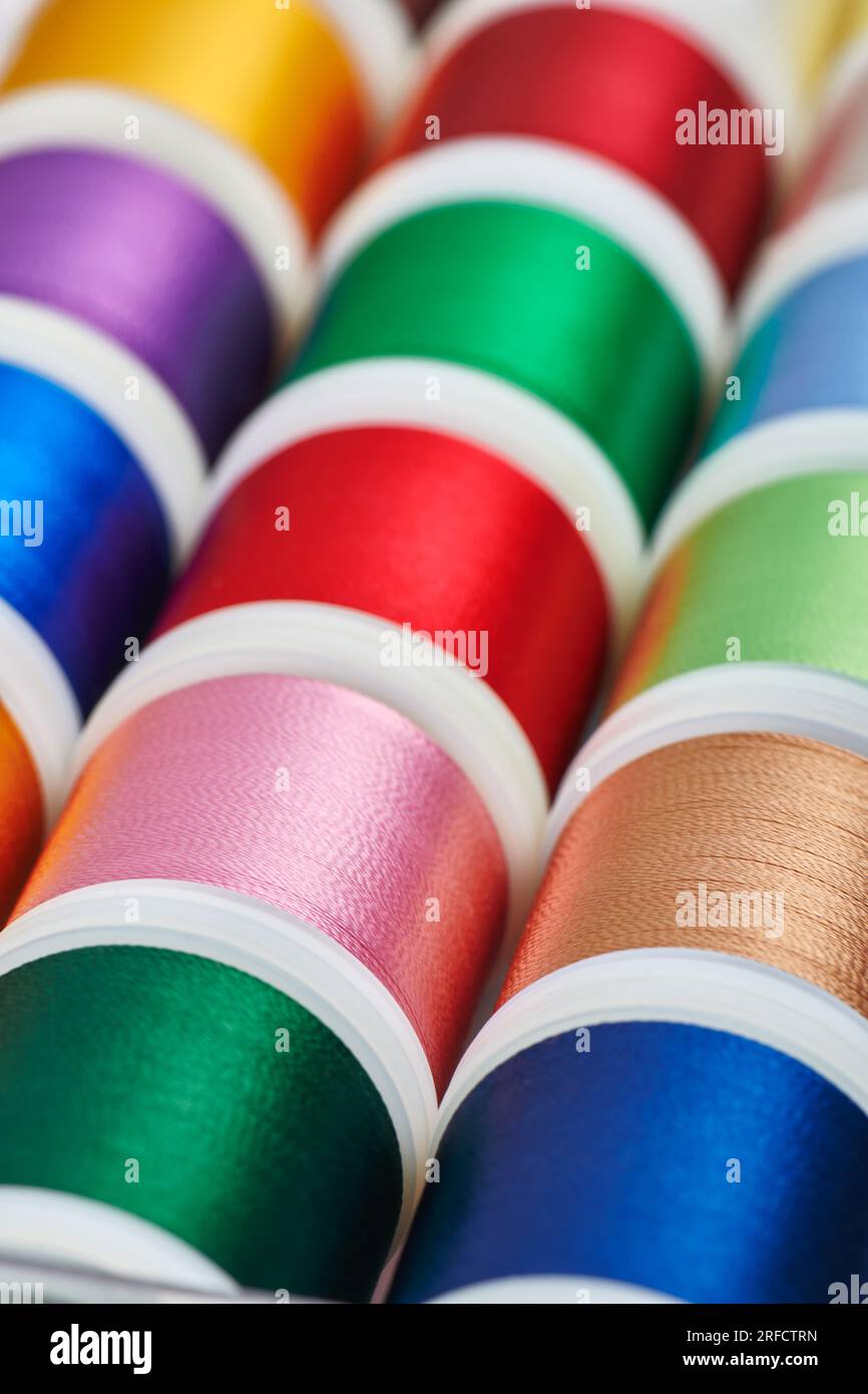 Background from spools with multicolored sewing threads Stock Photo