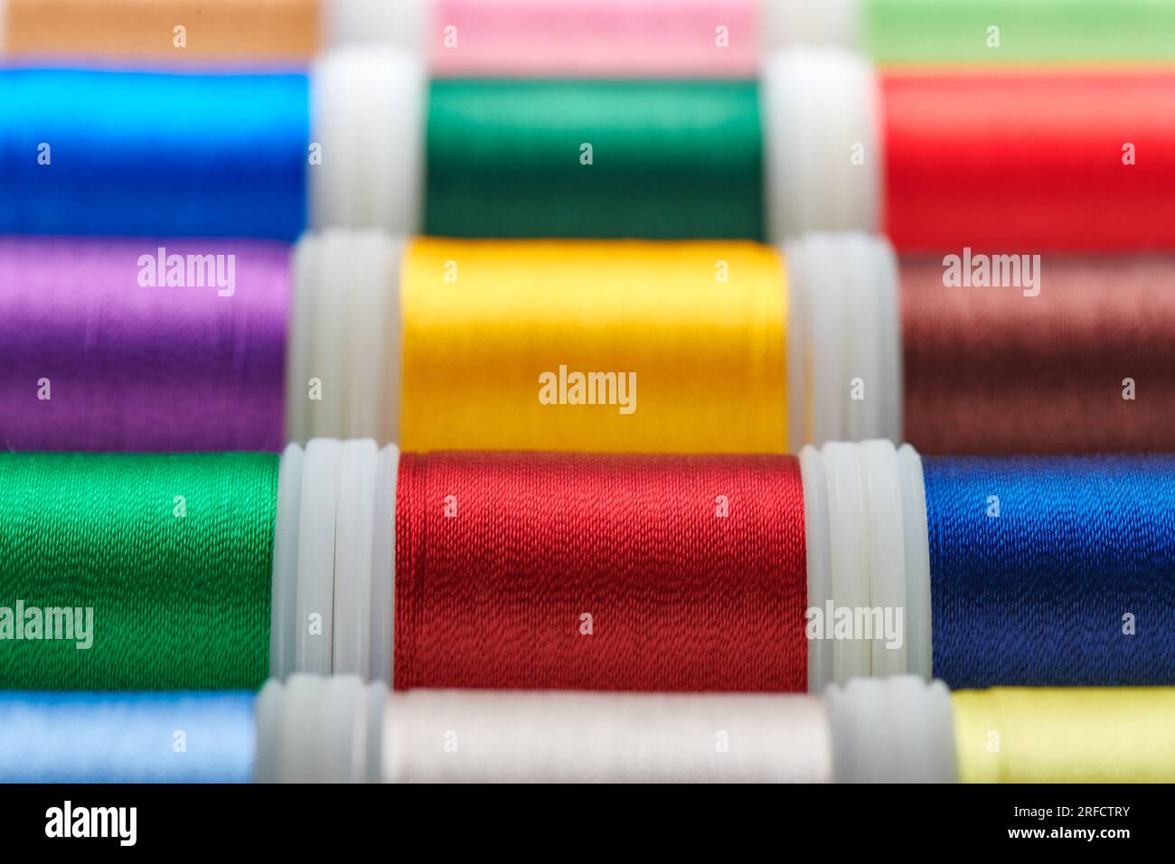 Background from spools with multicolored sewing threads Stock Photo