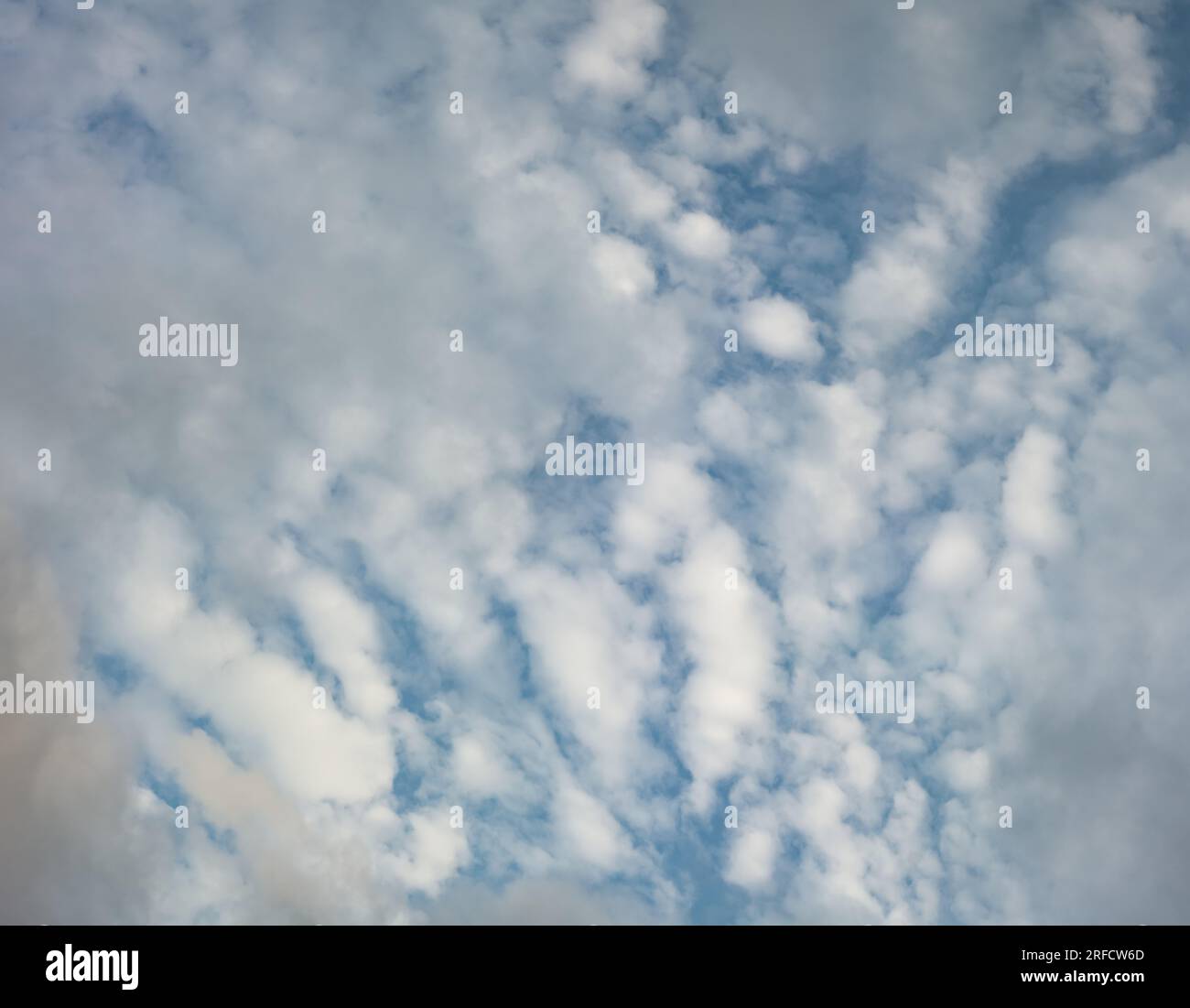 Altocumulus clouds seen through a layer of fast moving stratus clouds