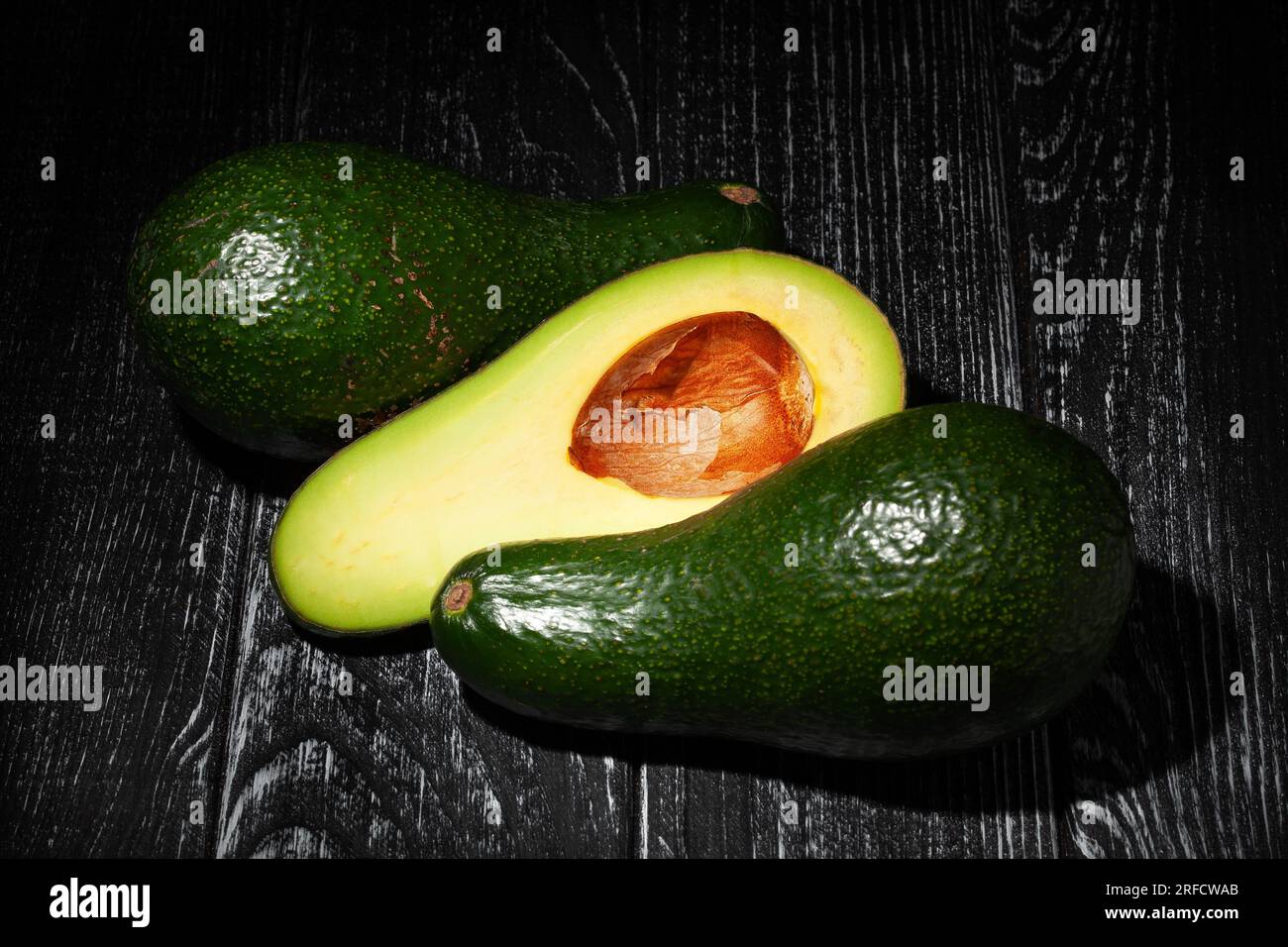 sliced avocado on wood background Stock Photo