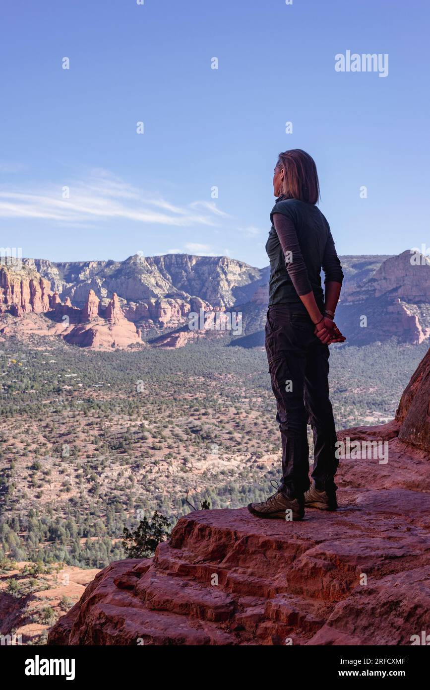 A woman enjoys the expansive views over the valley below overlooking Sedona in Arizona USA Stock Photo