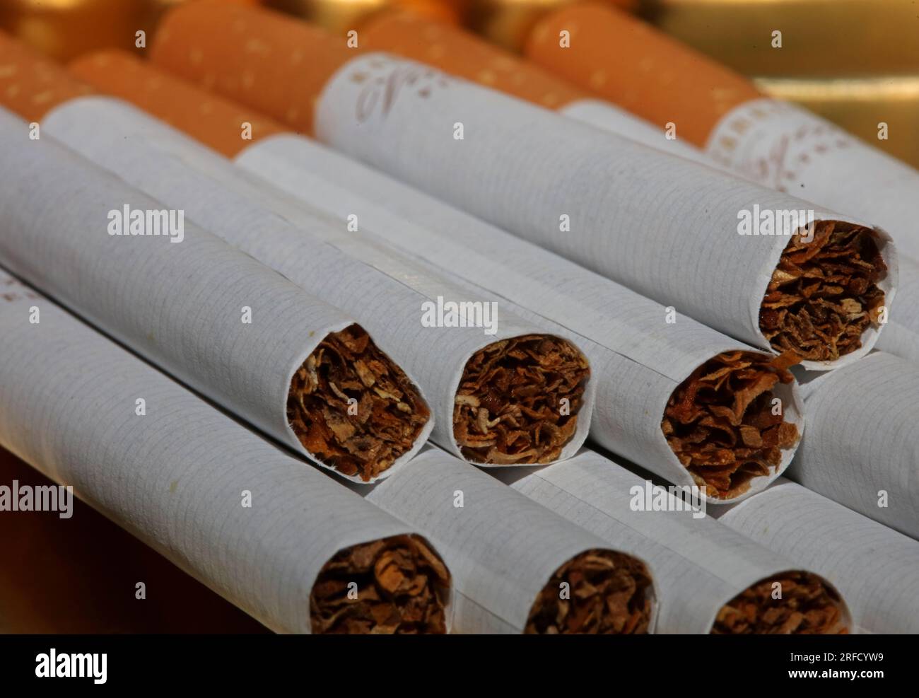 Many cigarettes in colorful background close up of a roll tobacco in paper with filter tube no