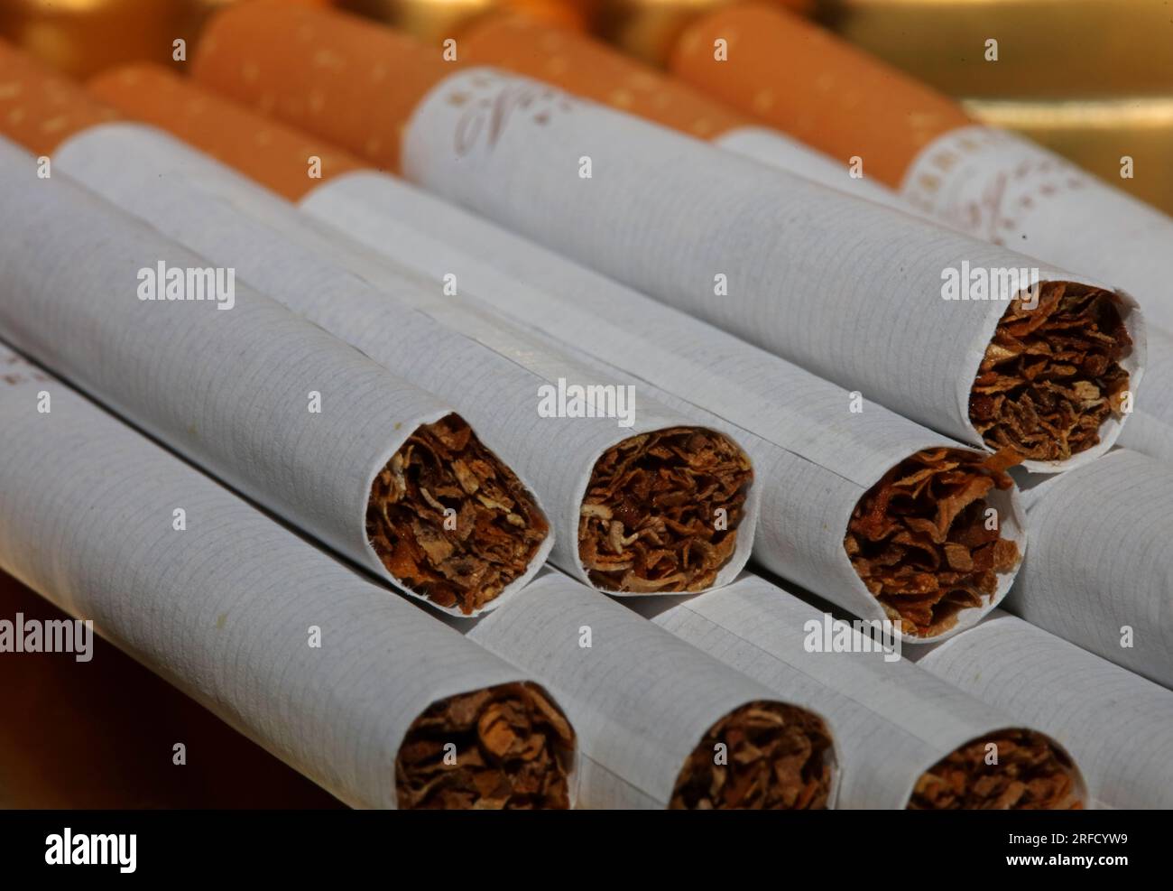 Many cigarettes in colorful background close up of a roll tobacco in paper with filter tube no smoking concept image of several commercially made ciga Stock Photo