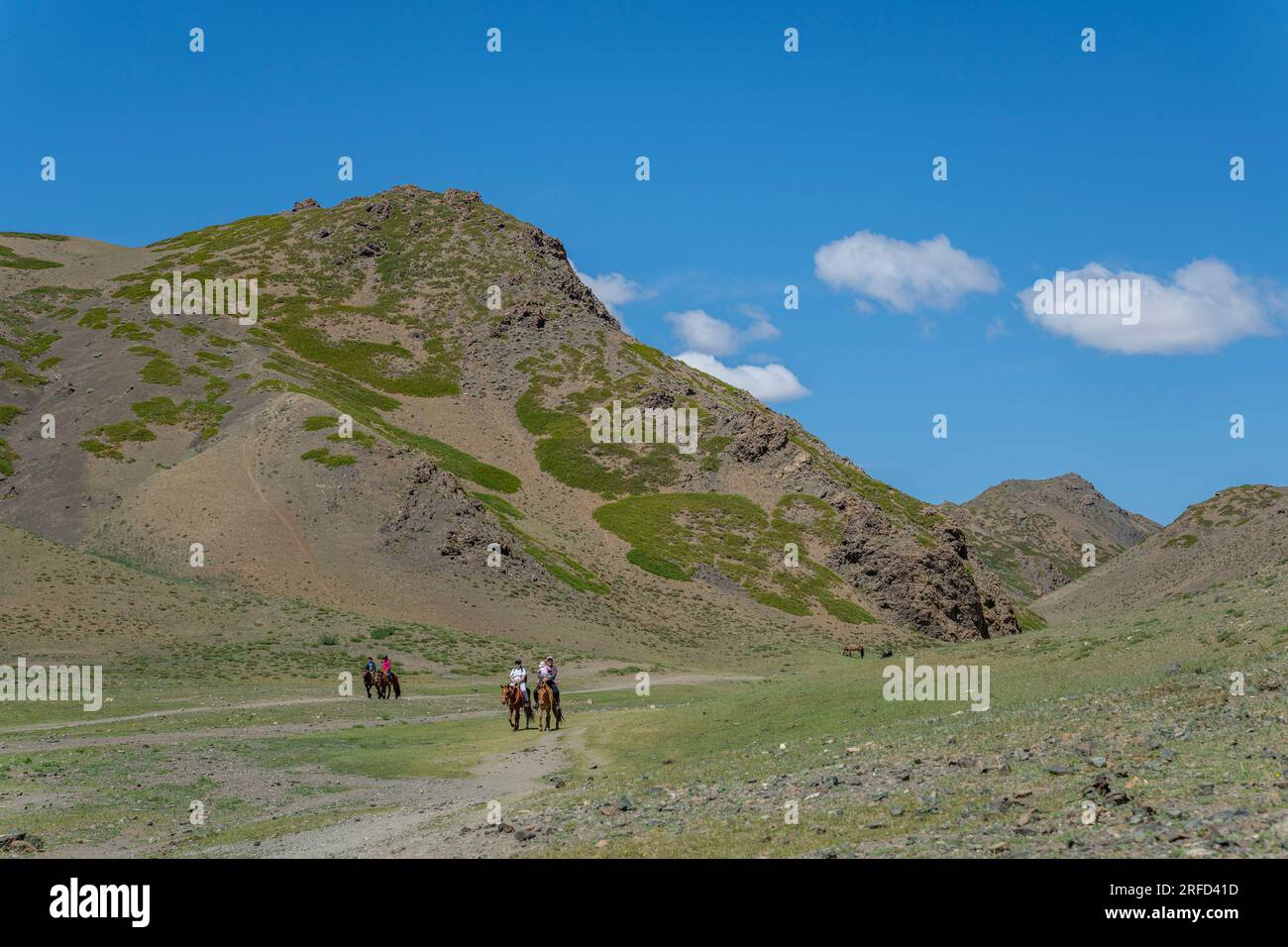 A Mongolian family on horseback in the Yolyn Am (Gurvan Saikhan National Park), a deep and narrow gorge in the Gurvan Saikhan Mountains near Dalanzadg Stock Photo