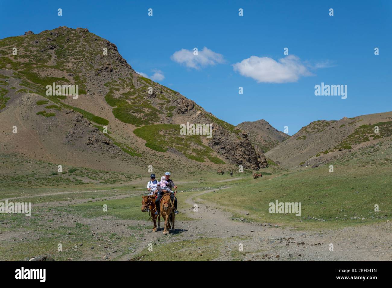 A Mongolian family on horseback in the Yolyn Am (Gurvan Saikhan National Park), a deep and narrow gorge in the Gurvan Saikhan Mountains near Dalanzadg Stock Photo