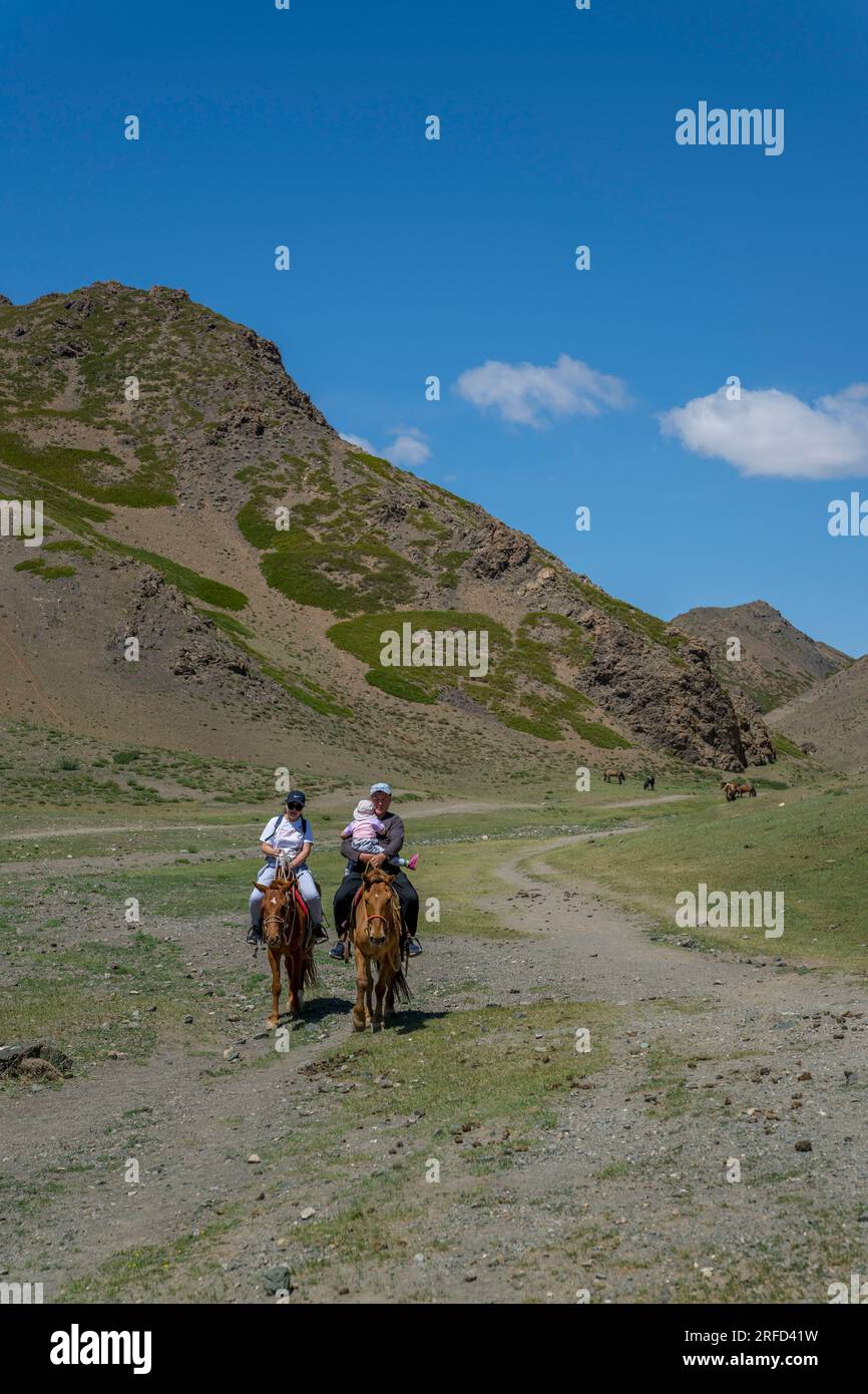 A Mongolian family on horseback in the Yolyn Am (Gurvan Saikhan National Park), a deep and narrow gorge in the Gurvan Saikhan Mountains near Dalanzadg Stock Photo