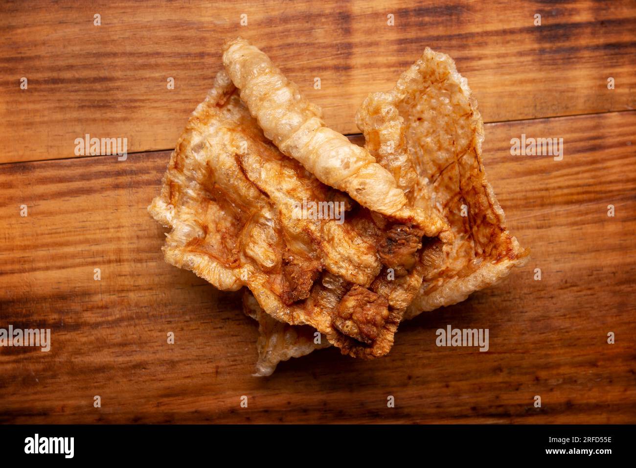 Chicharron. Crispy Fried pork rind, are pieces of aired and fried pork skin, traditional Mexican ingredient or snack. Table topview. Stock Photo