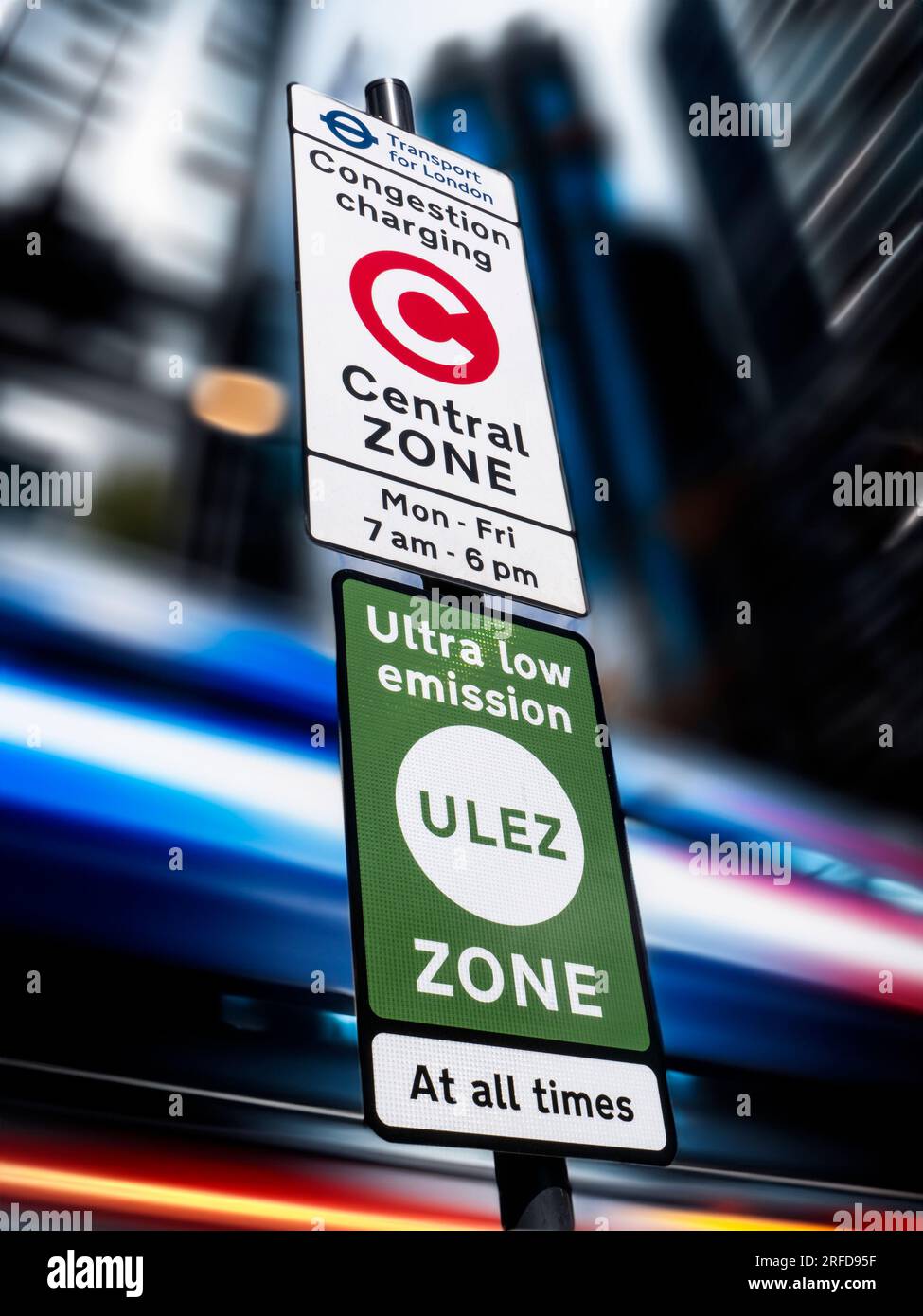 'ULEZ' ZONE SIGN SIGNAGE TFL  London area city town background Congestion/Emission charging London zone sign with 'ULEZ' ultra low emission zone sign against blurred traffic and city buildings London UK Stock Photo