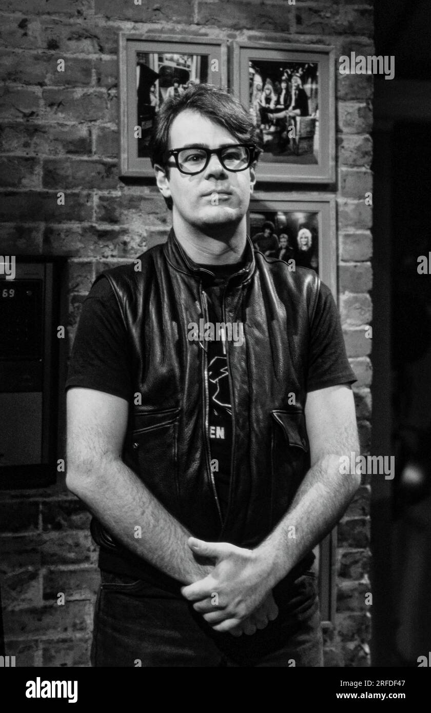 Commedian/Actor Dan Aykroyd on MusicTelevision - MTV - set in 1982. Bernard Gotfryd photograph. Daniel Edward Aykroyd  is a Canadian actor, comedian, screenwriter, producer, and musician. Aykroyd was a writer and an original member of the 'Not Ready for Prime Time Players' cast on the NBC sketch comedy series Saturday Night Live from its inception in 1975 until his departure in 1979. During his tenure on SNL, he appeared in a recurring series of sketches, particularly featuring the Coneheads and the Blues Brothers. Stock Photo