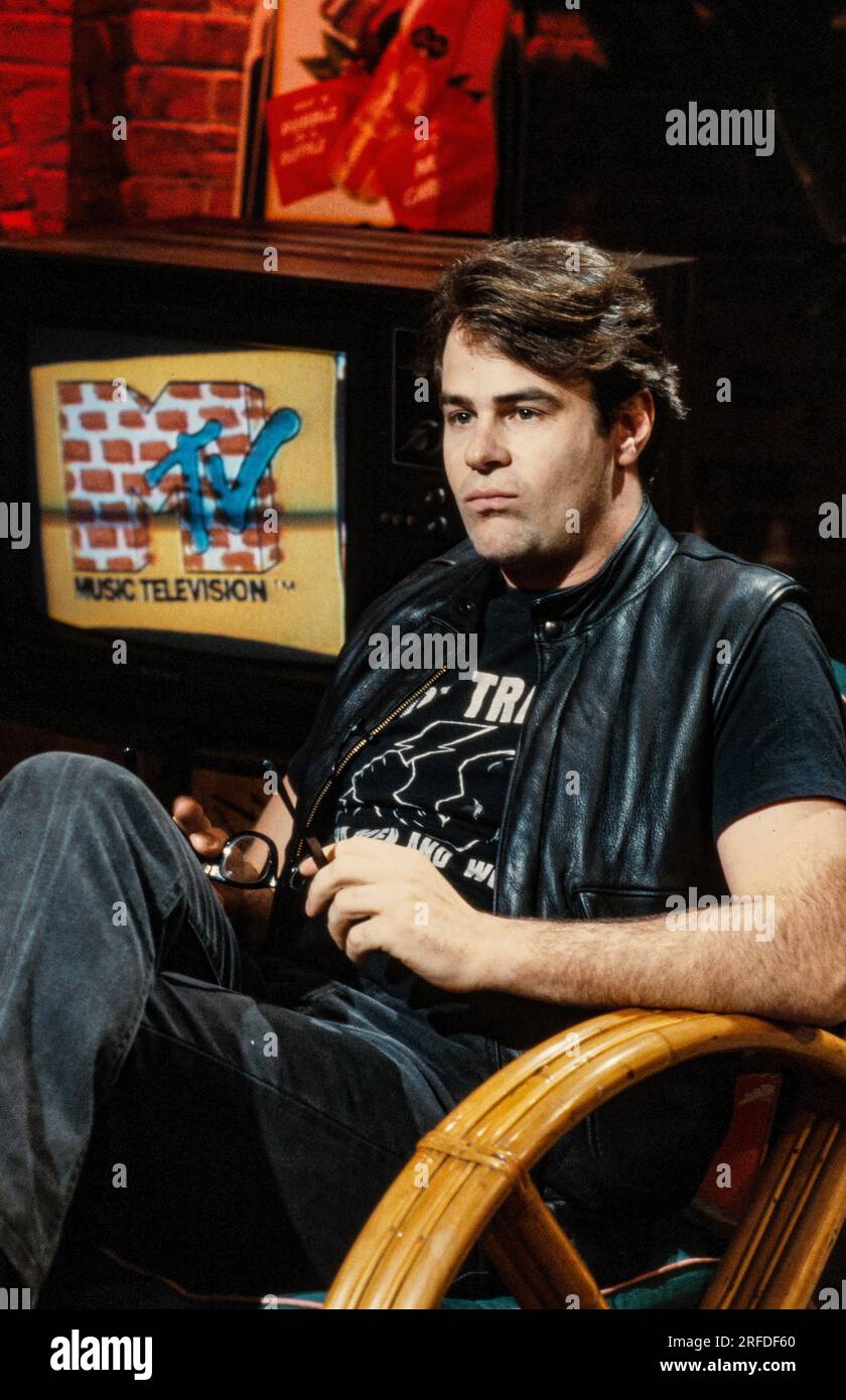 Commedian/Actor Dan Aykroyd on MusicTelevision - MTV - set in 1982. Bernard Gotfryd photograph. Daniel Edward Aykroyd  is a Canadian actor, comedian, screenwriter, producer, and musician. Aykroyd was a writer and an original member of the 'Not Ready for Prime Time Players' cast on the NBC sketch comedy series Saturday Night Live from its inception in 1975 until his departure in 1979. During his tenure on SNL, he appeared in a recurring series of sketches, particularly featuring the Coneheads and the Blues Brothers. Stock Photo