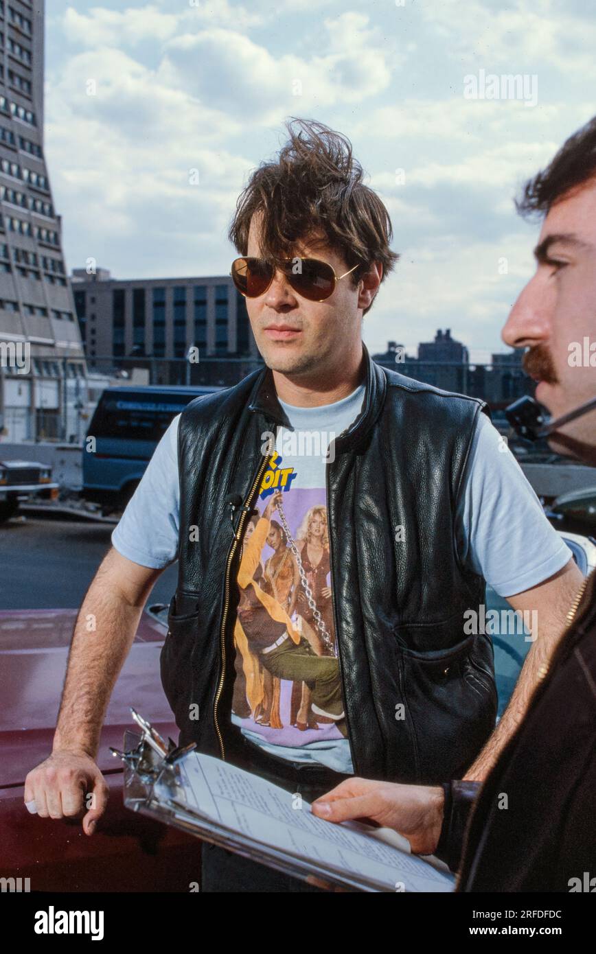 Commedian/Actor Dan Aykroyd on set in 1982. Bernard Gotfryd photograph. Daniel Edward Aykroyd is a Canadian actor, comedian, screenwriter, producer, and musician. Aykroyd was a writer and an original member of the 'Not Ready for Prime Time Players' cast on the NBC sketch comedy series Saturday Night Live from its inception in 1975 until his departure in 1979. During his tenure on SNL, he appeared in a recurring series of sketches, particularly featuring the Coneheads and the Blues Brothers. Stock Photo