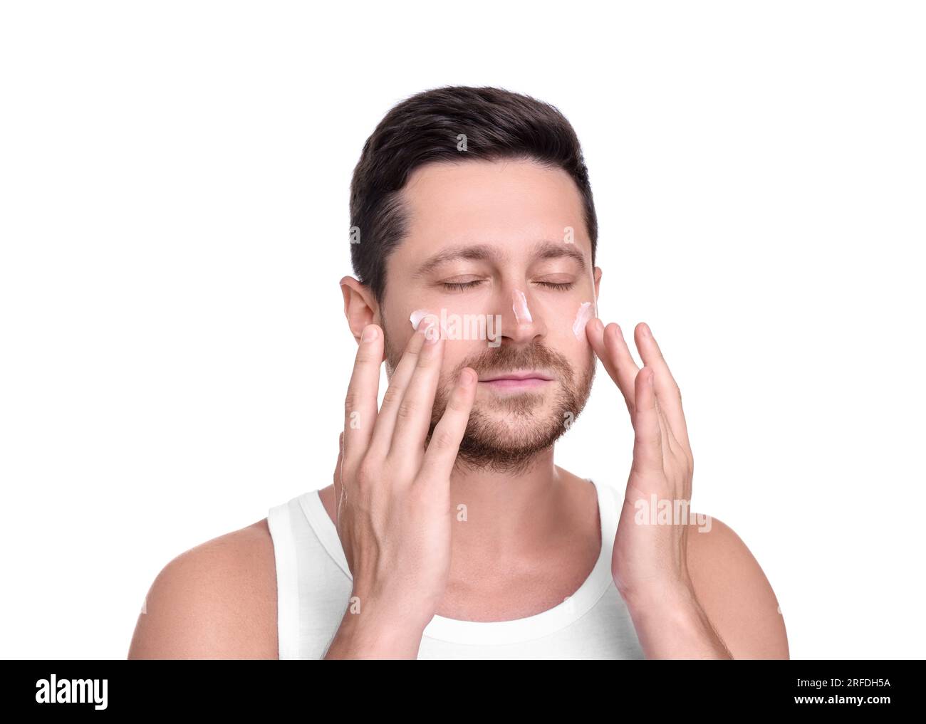 Man applying sun protection cream onto his face against white background Stock Photo