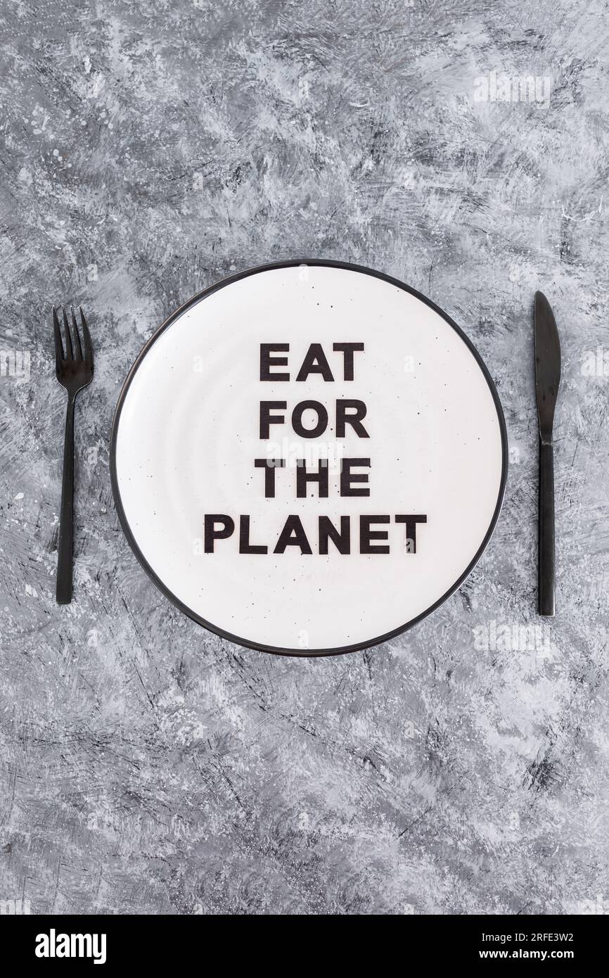 Eat for the planet text on plate with fork and knife, concept of sustainable dietary options Stock Photo