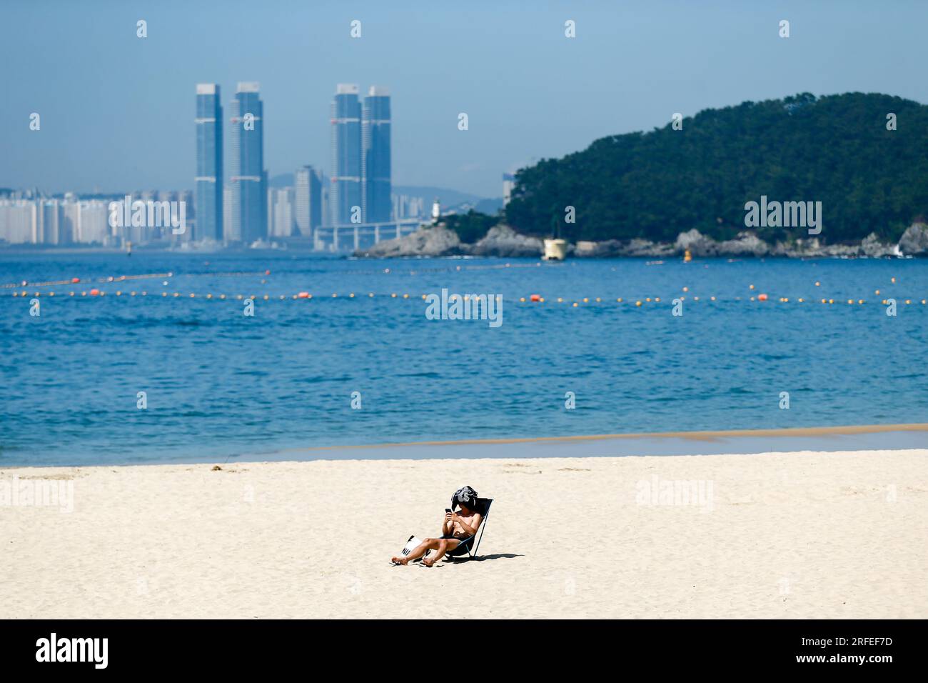 Busan, South Korea. 3rd Aug, 2023. A man rests on a beach on a hot ...