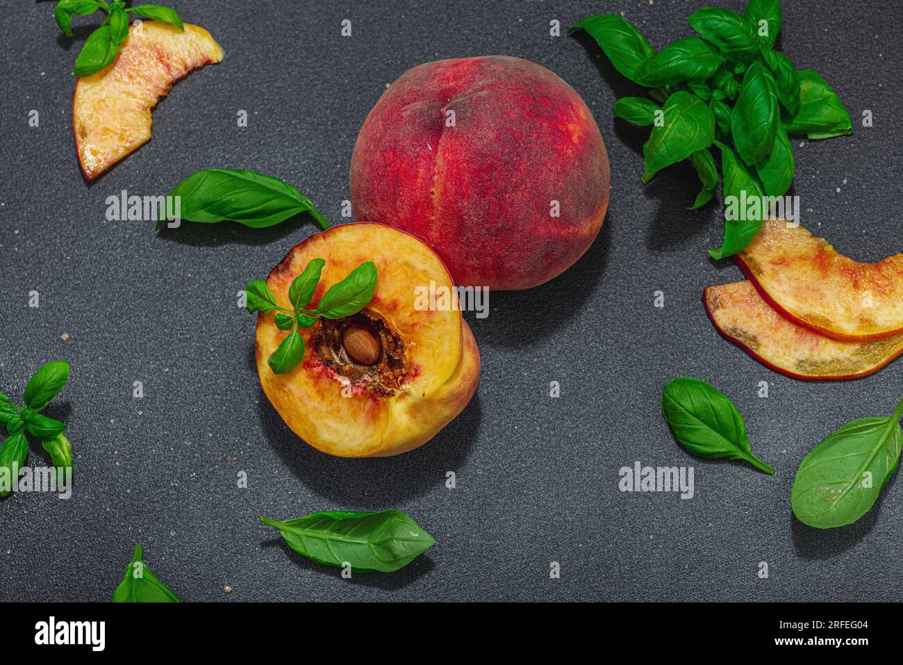 Fruit culinary background. Ripe peaches and fresh basil leaves. Modern ...