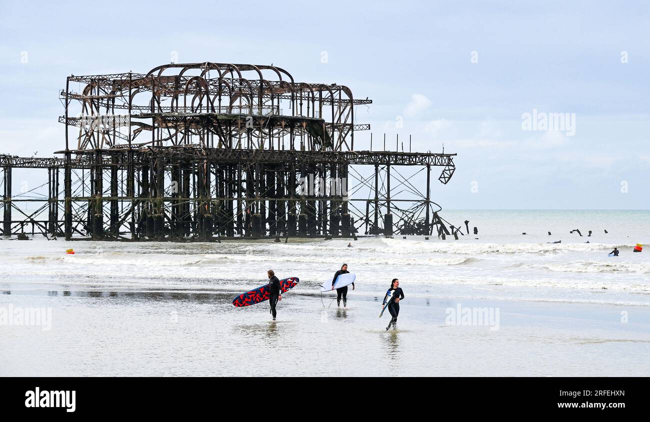 Brighton UK 3rd August 2023 - Surfers after enjoying the wave conditions in Brighton by the West Pier after Storm Patricia passed through yesterday as the dreary summer weather continues in Britain : Credit Simon Dack / Alamy Live News Stock Photo