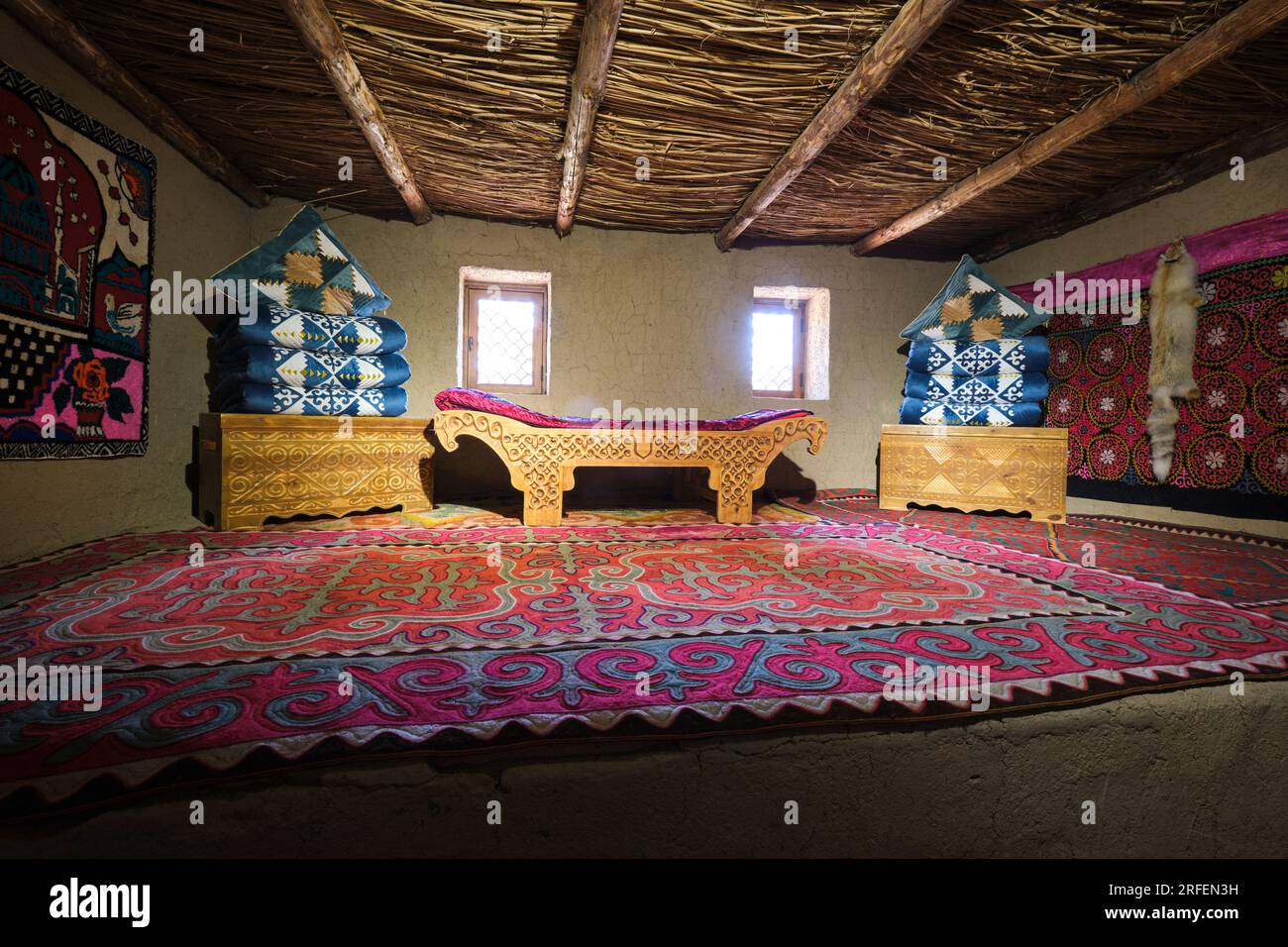 A traditional Kazakh sitting room with wood carved daybed sofa and many ...