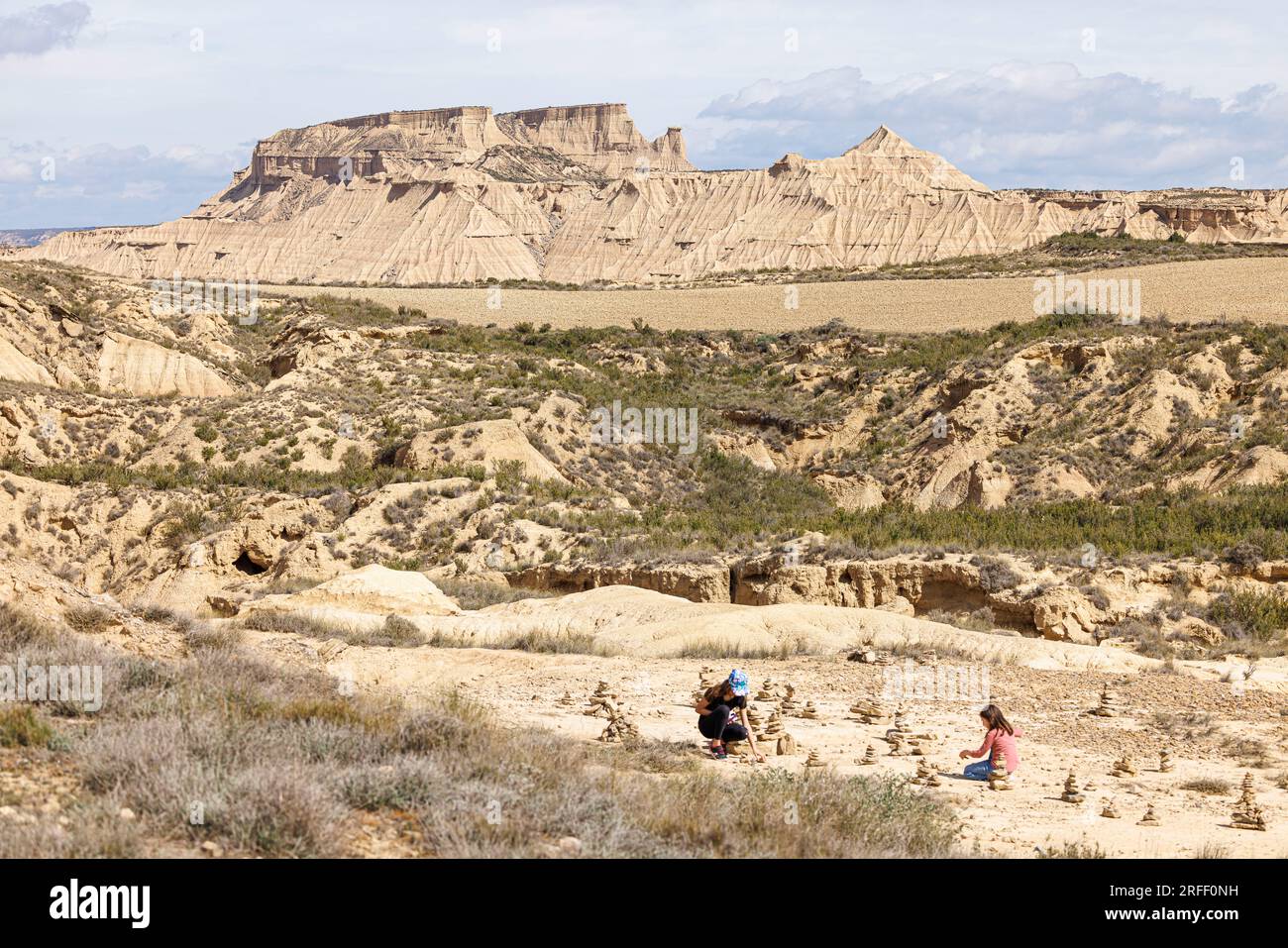 Spain, Navarra, Arguedas, The Bardenas Reales Biosphere Reserve and natural park listed as World Heritage by UNESCO, Bardena Blanca, young girls making cairn Stock Photo