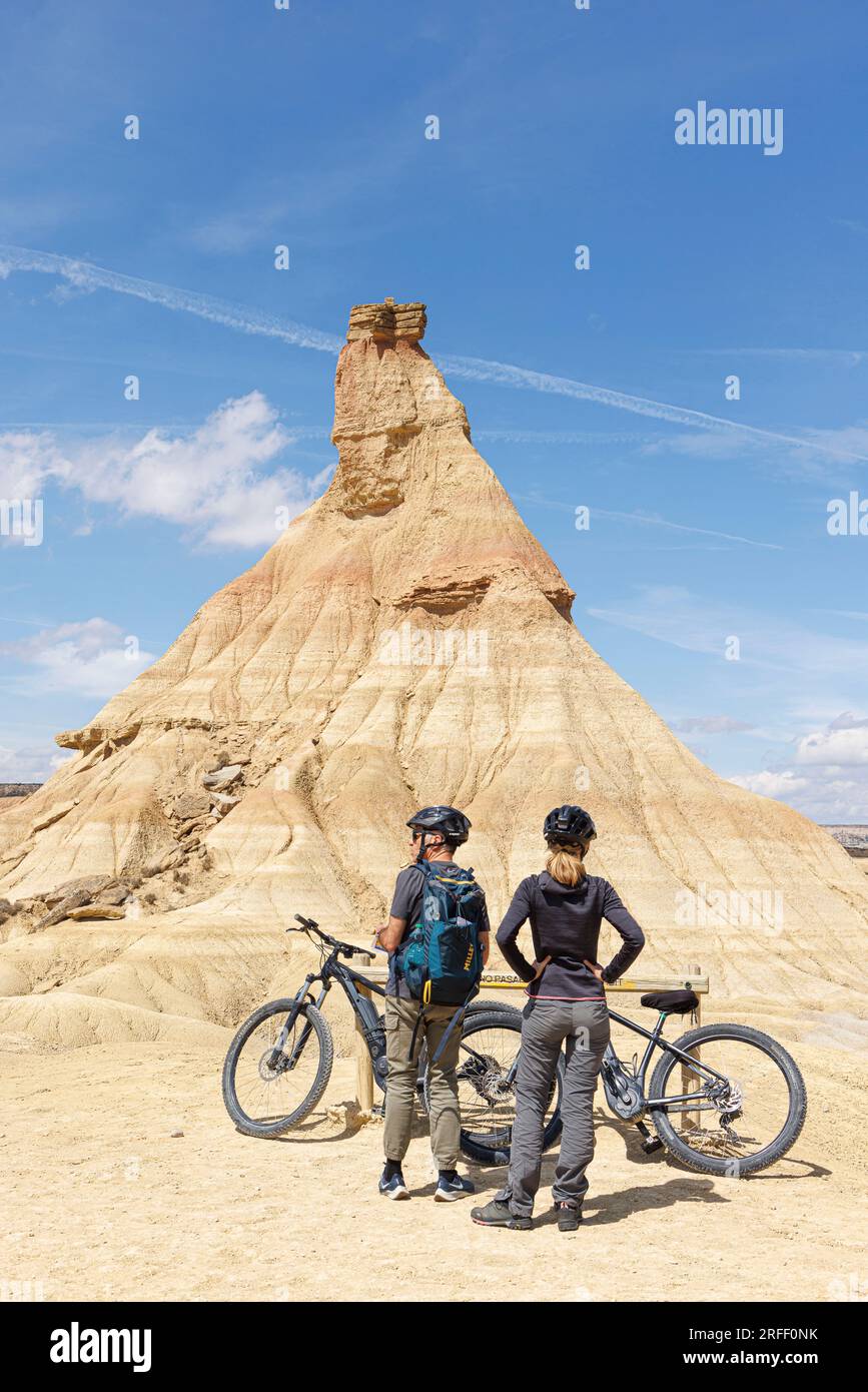 Spain, Navarra, Arguedas, The Bardenas Reales Biosphere Reserve and natural park listed as World Heritage by UNESCO, Bardena Blanca, couple with bicycles before el Cabezo de Castildetierra Stock Photo