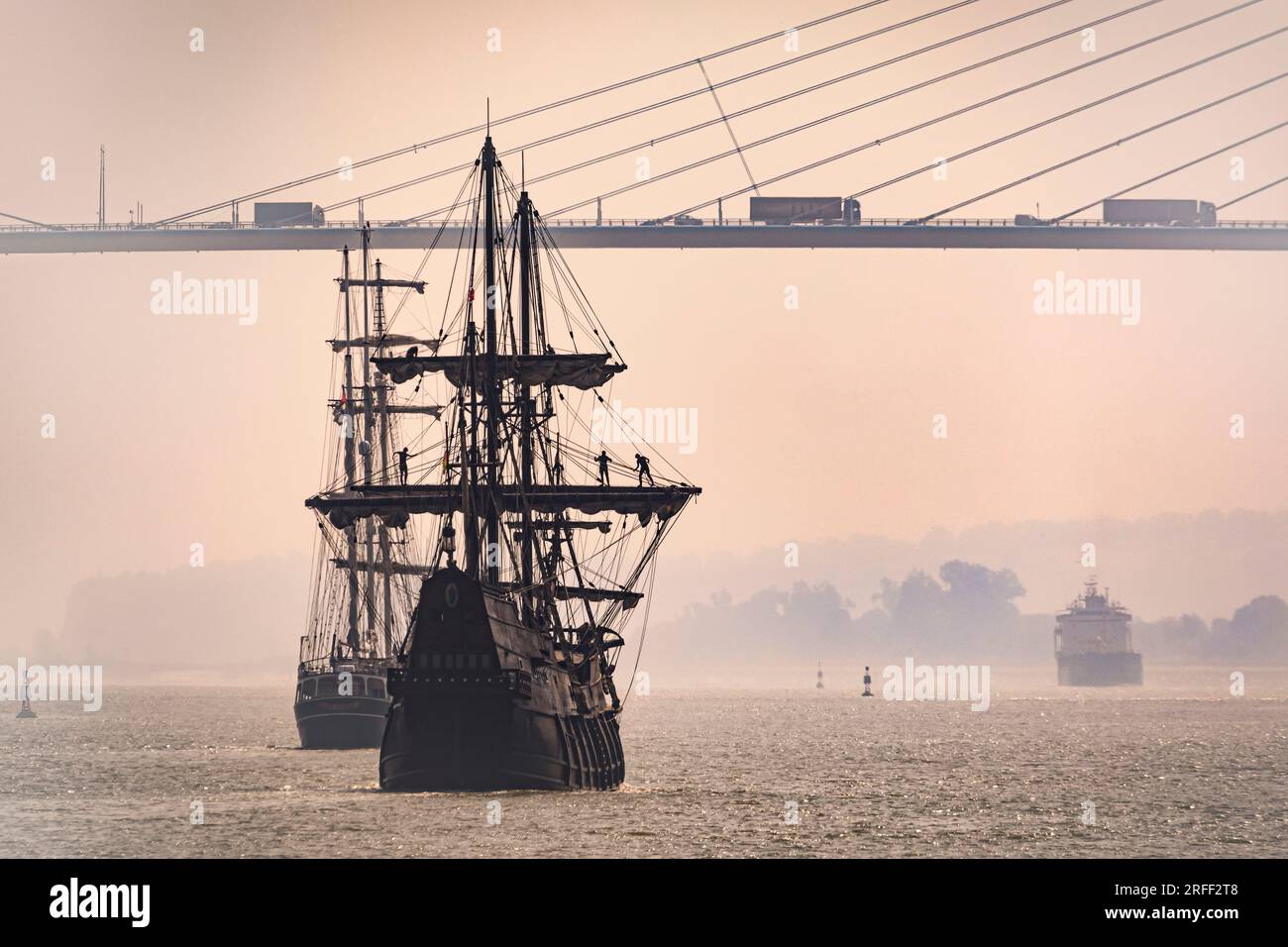 France, Calvados, Honfleur, Armada 2023, El Galeon, replica of a 16th century Spanish galleon, arrives in the bay of the Seine river, with sailors working in the yards, Normandy Bridge in the background Stock Photo