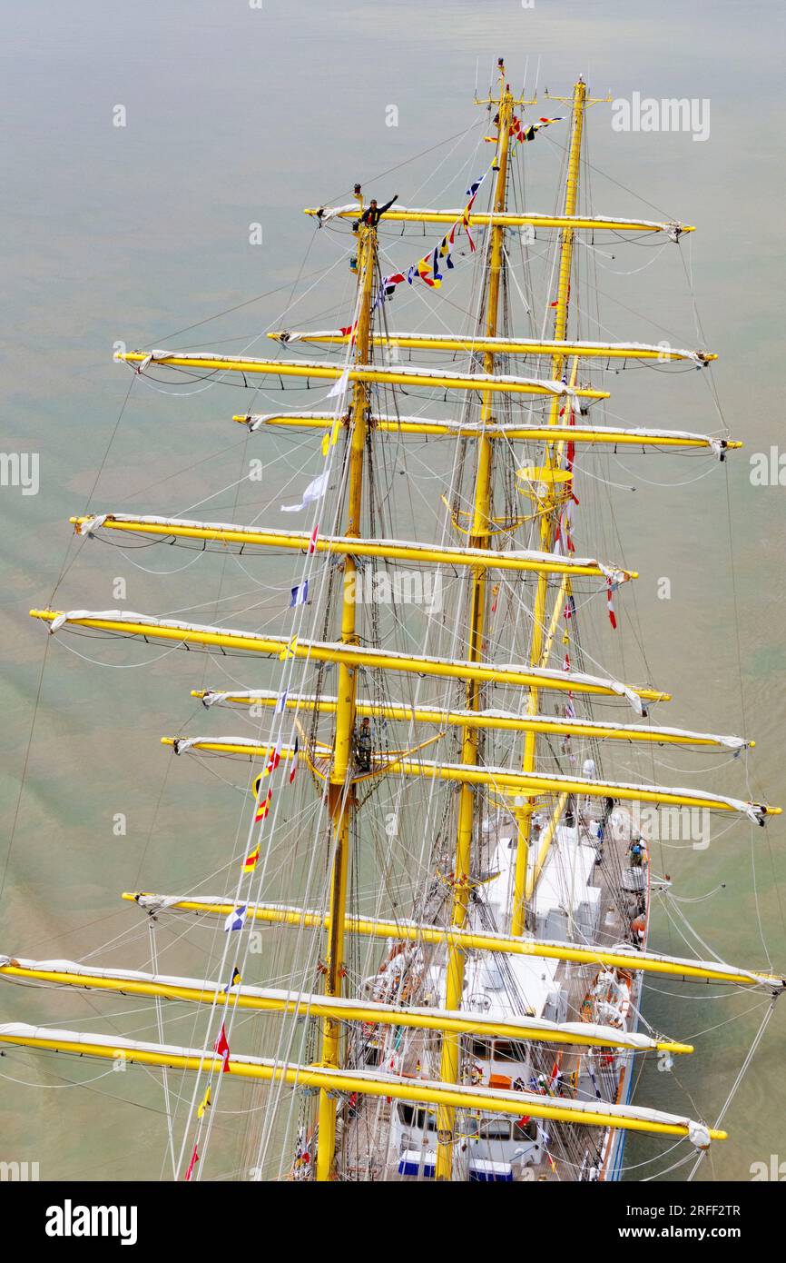 France, Seine-Maritime, Caudebec-en-Caux, also called Rives-en-Seine, Armada 2023, Indonesian training ship three-masted barque Bima Suci sails in front of the town, bird's eye view of a sailor saluting, standing on the crow's nest mast, sailing under Brotonne Bridge Stock Photo