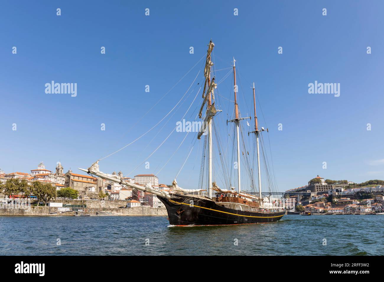 The Gulden Leeuw, or Golden Lion, on the Douro River with the Portuguese city of Porto in the background.   The three-masted topsail schooner was buil Stock Photo