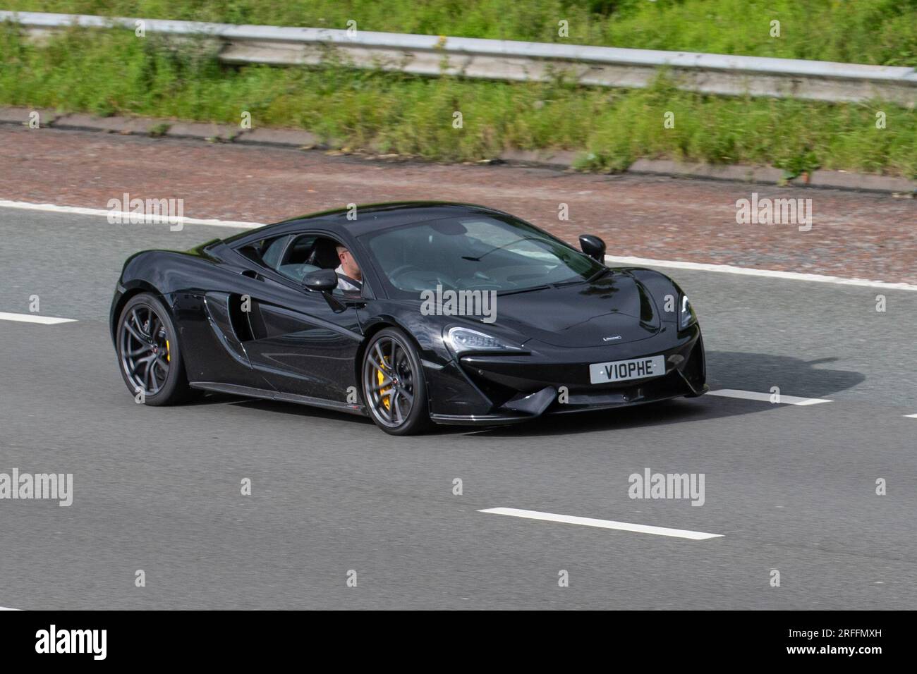 2016 Black Mclaren 570S Coupe S-A V8 VVT Twin Turbo SSG AutoCar Coupe Petrol 3799 cc travelling at speed on the M6 motorway in Greater Manchester, UK Stock Photo