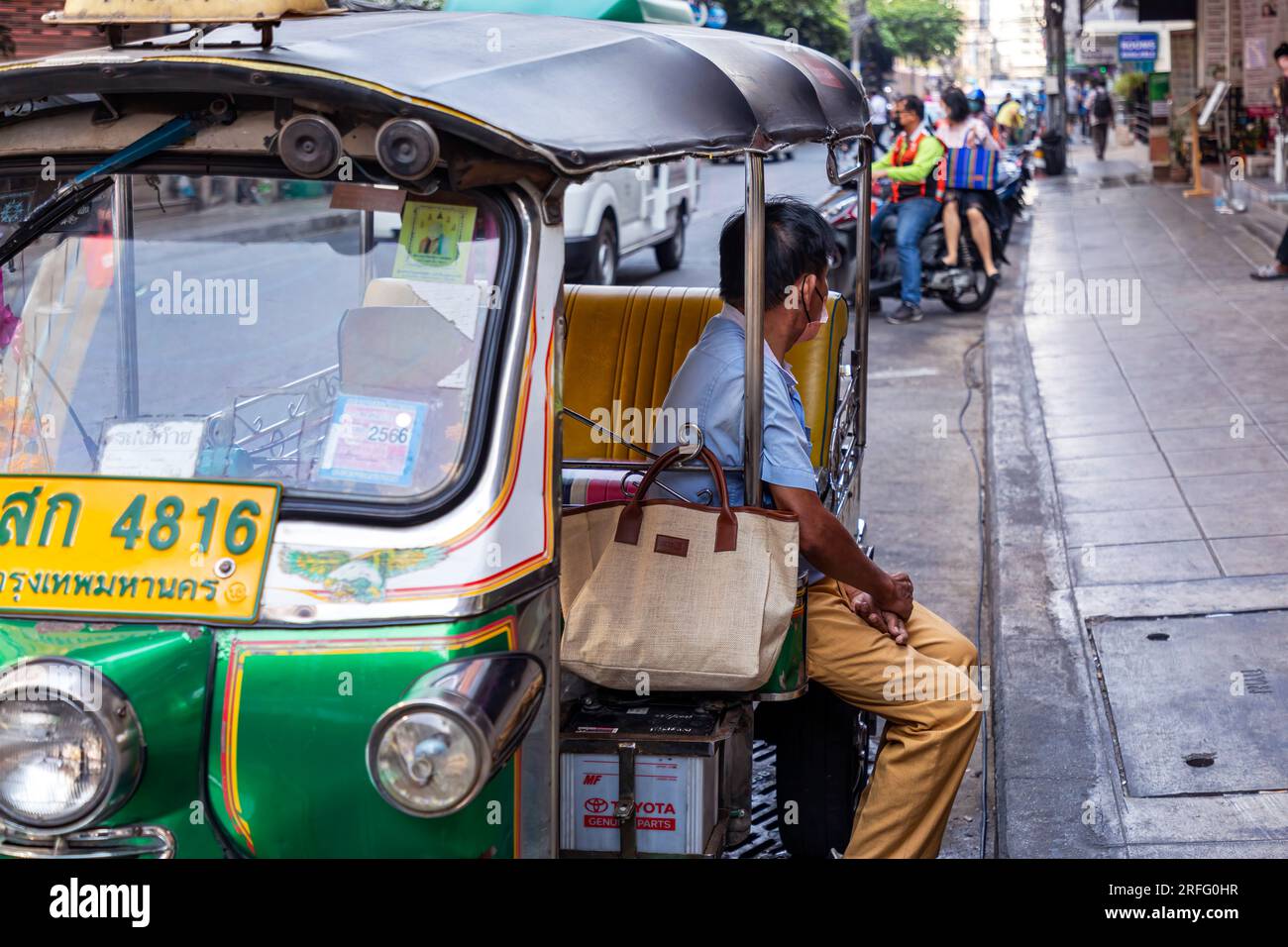 Thai tuk tuk driver waiting for tourist customer, Sukhumvit, Bangkok, Thailand Stock Photo