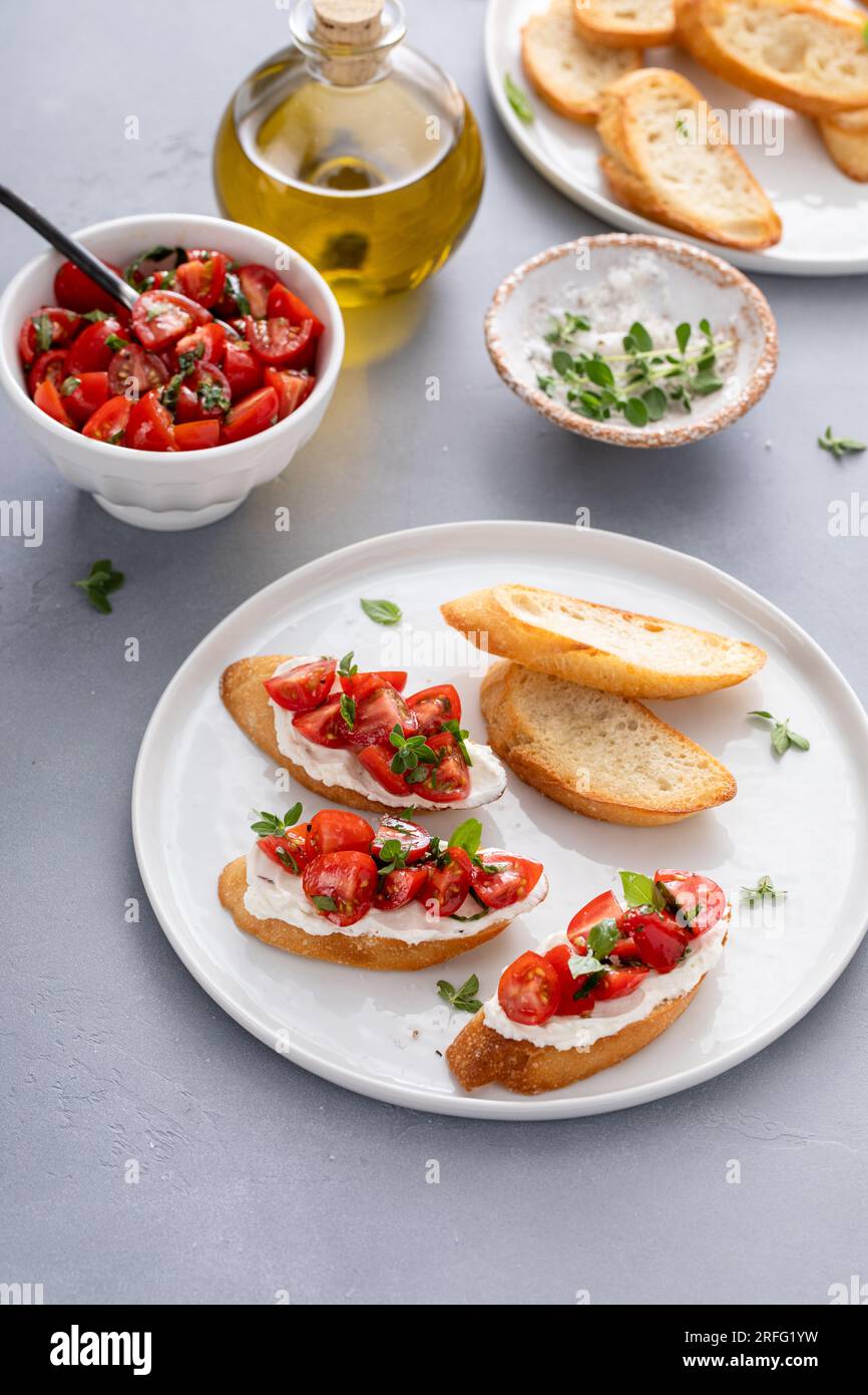Tomato basil and cream cheese bruschettas with fresh cherry tomatoes and herbs Stock Photo