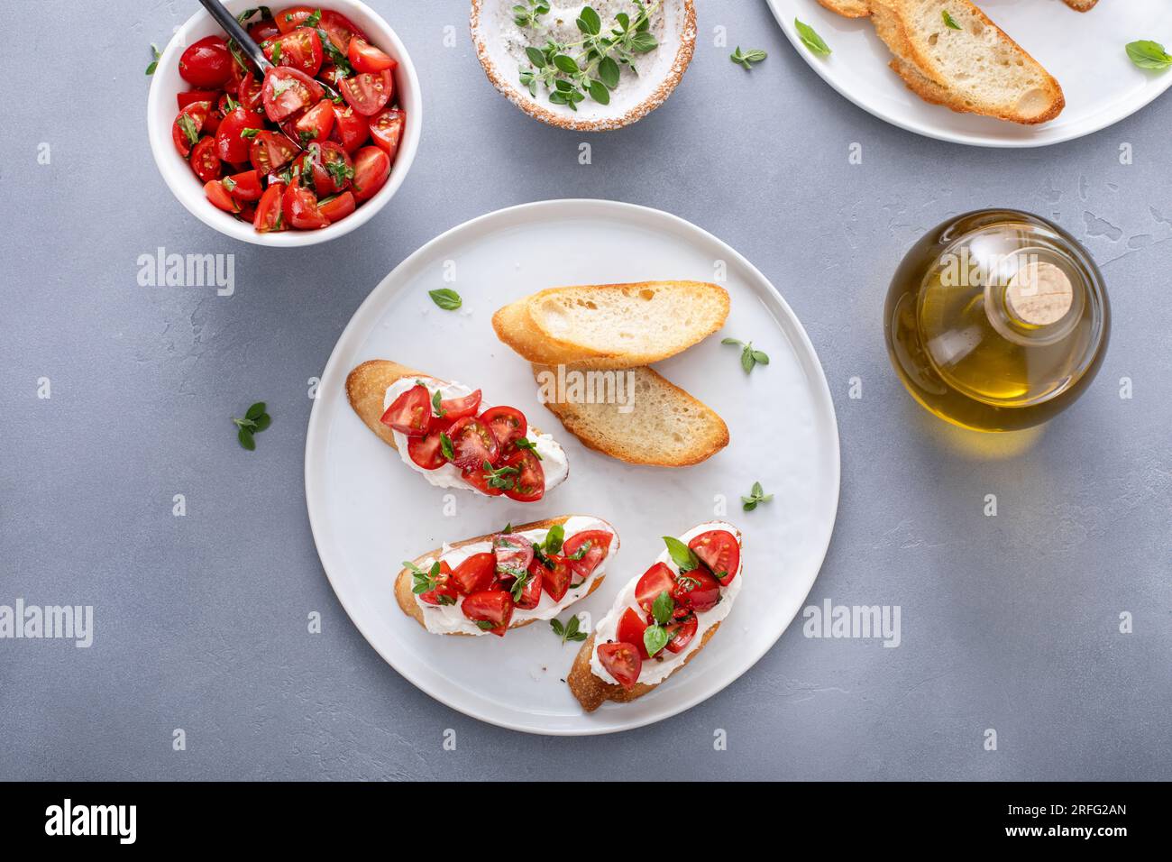 Tomato basil and cream cheese bruschettas with fresh cherry tomatoes and herbs Stock Photo