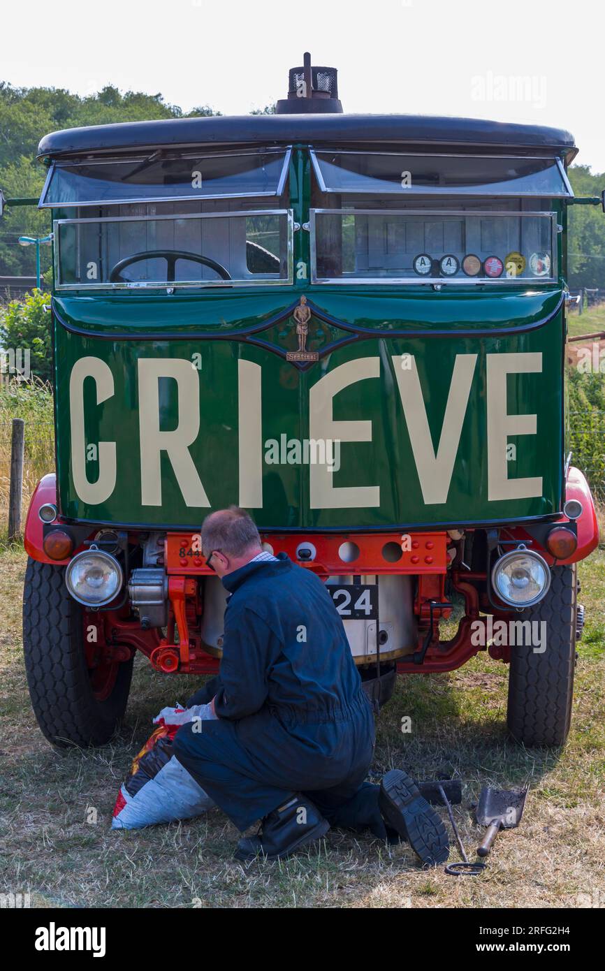 Man working on 1931 Sentinel steam lorry steam truck steam wagon at Roads to Rail Steam Rally at Norden, Dorset UK in June Stock Photo
