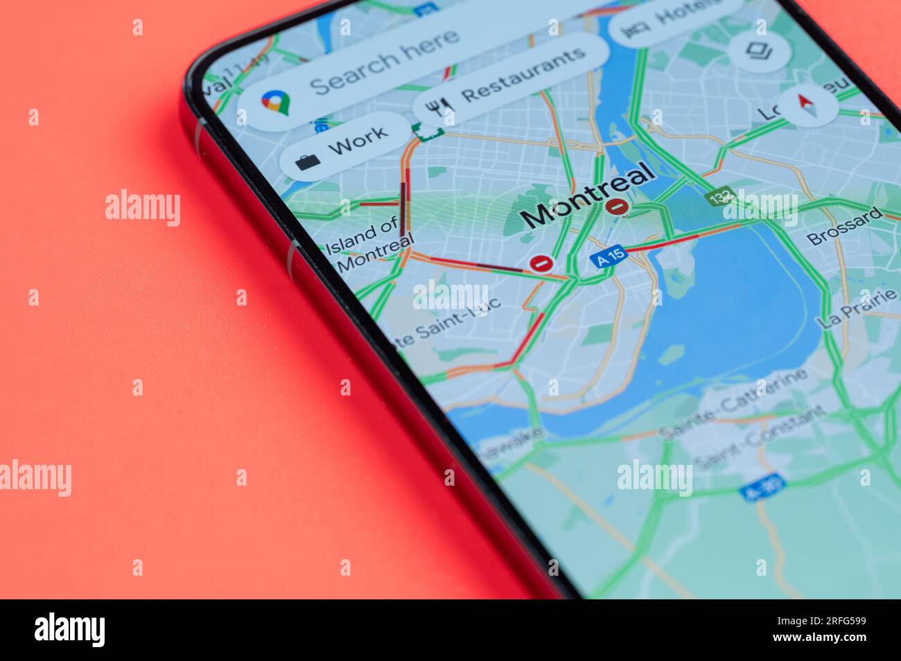 New York, USA - July 21, 2023: Car traffic on Montreal google maps on smartphone screen close up view with red background Stock Photo