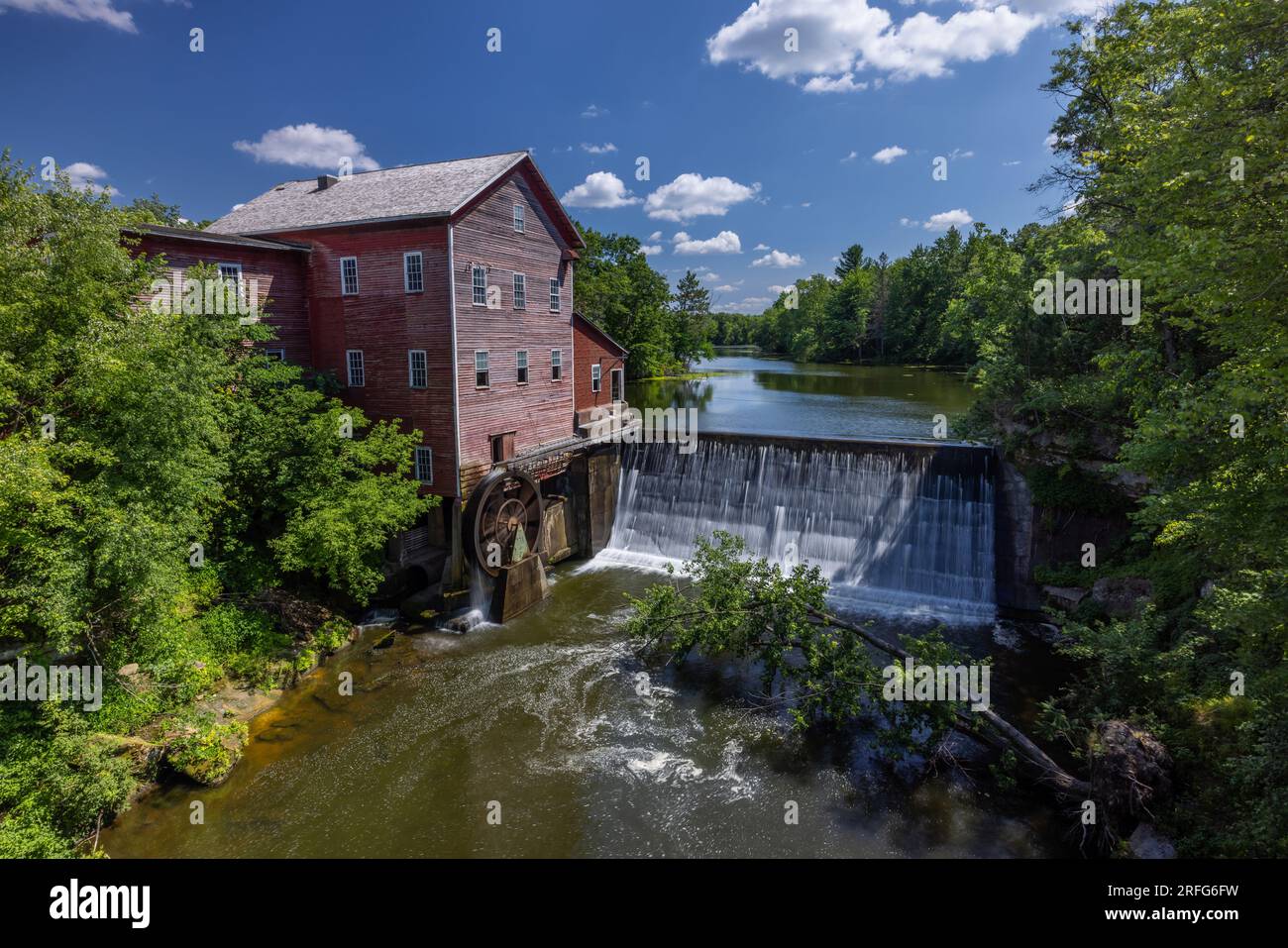 An old red grist mill with water wheel and dam Stock Photo Alamy