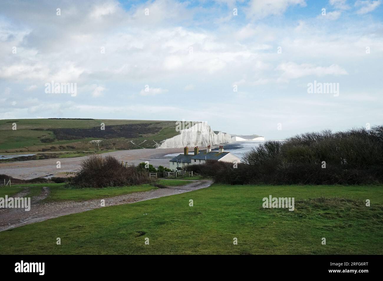 The great views from the top of the Seven Sisters chalk cliffs and national hillsides park with cloudy blue sky - East Sussex, England UK Stock Photo