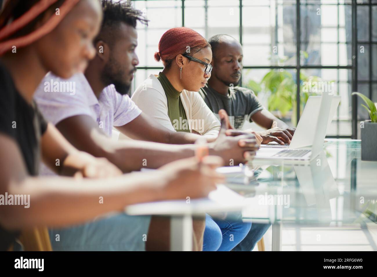 Employees working at computer together, discussing content. Stock Photo