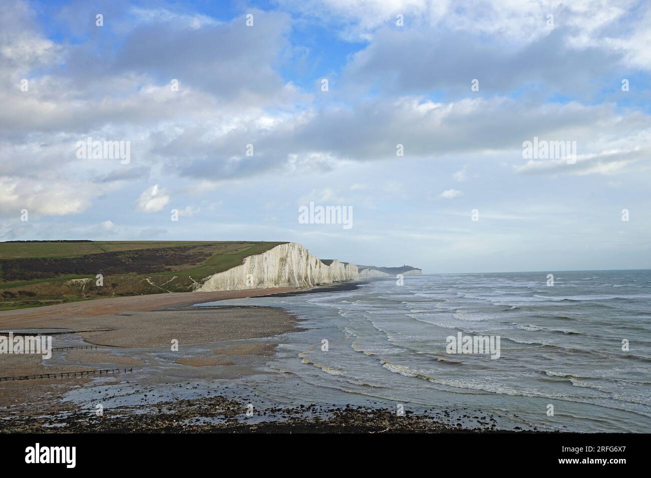 The great views from the top of the Seven Sisters chalk cliffs and national hillsides park with cloudy blue sky - East Sussex, England UK Stock Photo