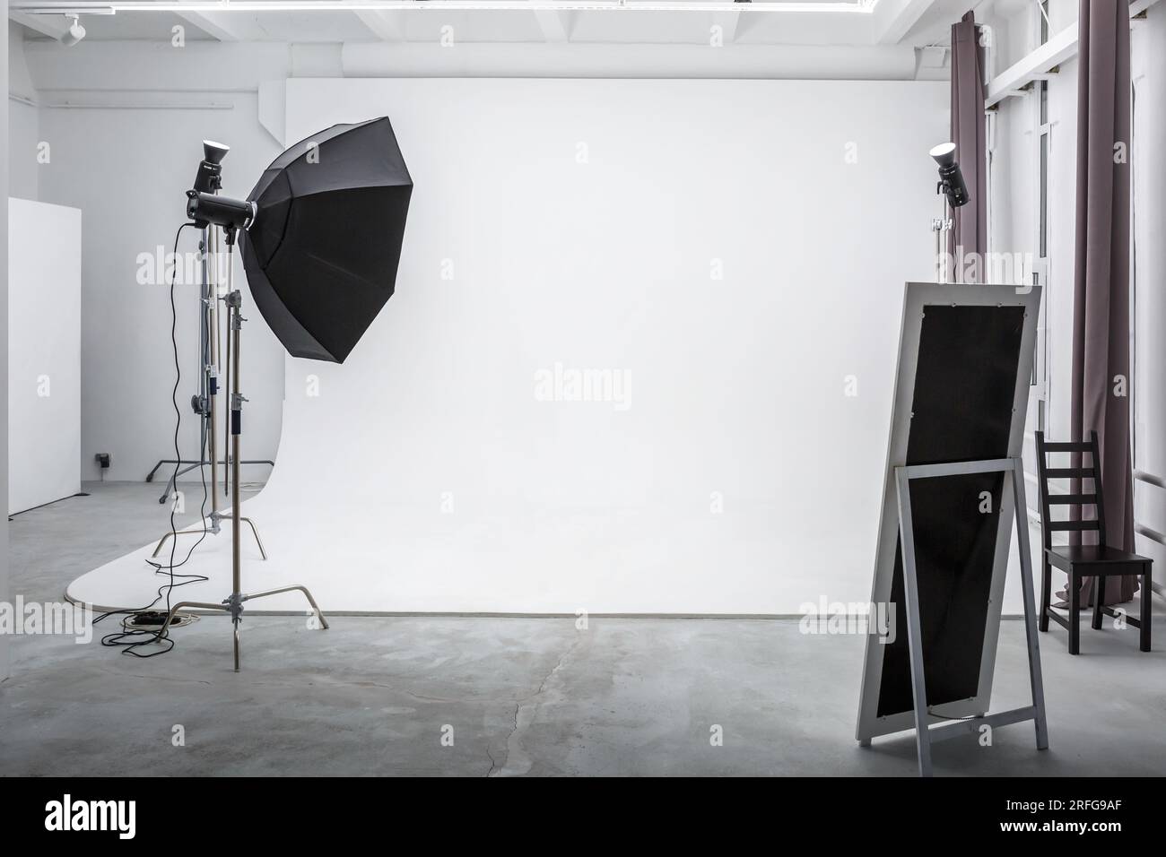 interior of bright space of photo studio with large white cyclorama with lighting equipment Stock Photo