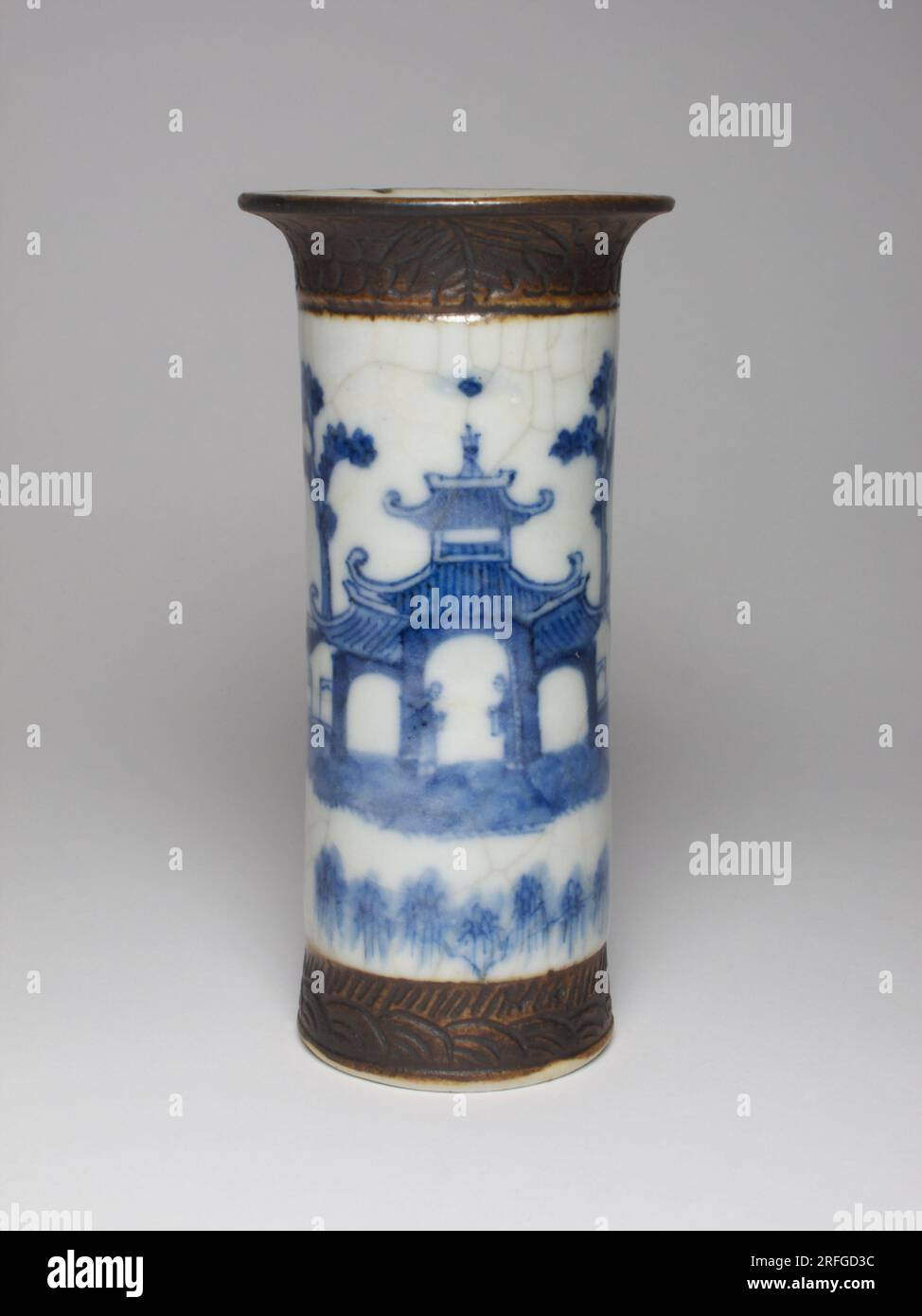 Chinese porcelain vase painted in underglaze blue with a pagoda scene with mountains to the background and with carved band to the foot and rim, made Stock Photo